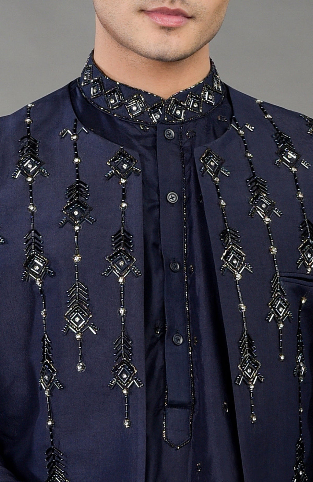 A man wears a blue geometric hand-embroidered jacket set with a matching kurta.