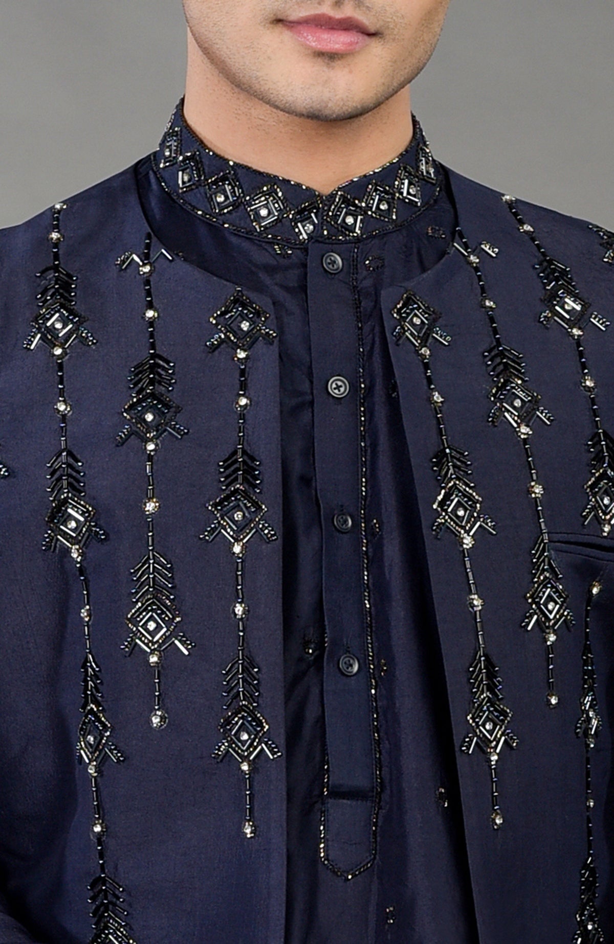 A man wears a blue geometric hand-embroidered jacket set with a matching kurta.