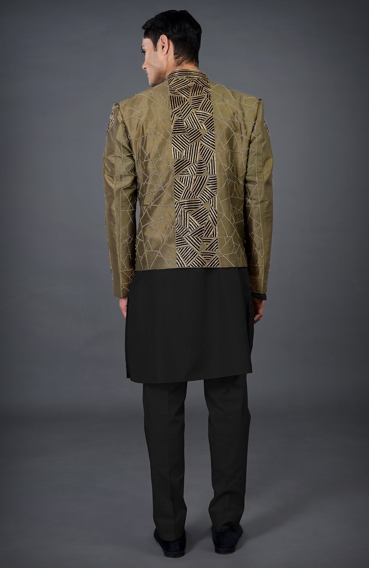 A man from behind wears an olive hand-embroidered jacket over a black kurta set.