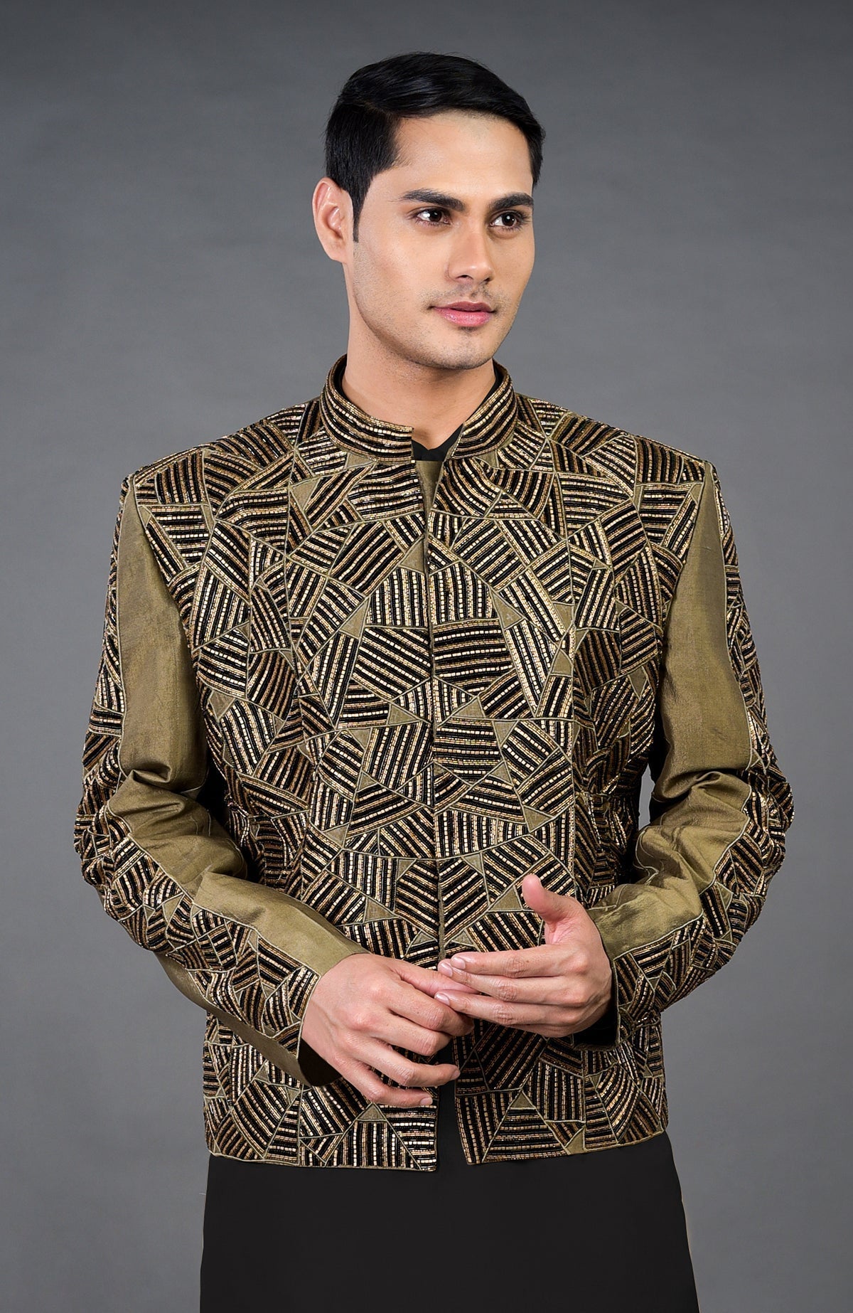 An olive hand-embroidered jacket set with black and gold abstract patterns.