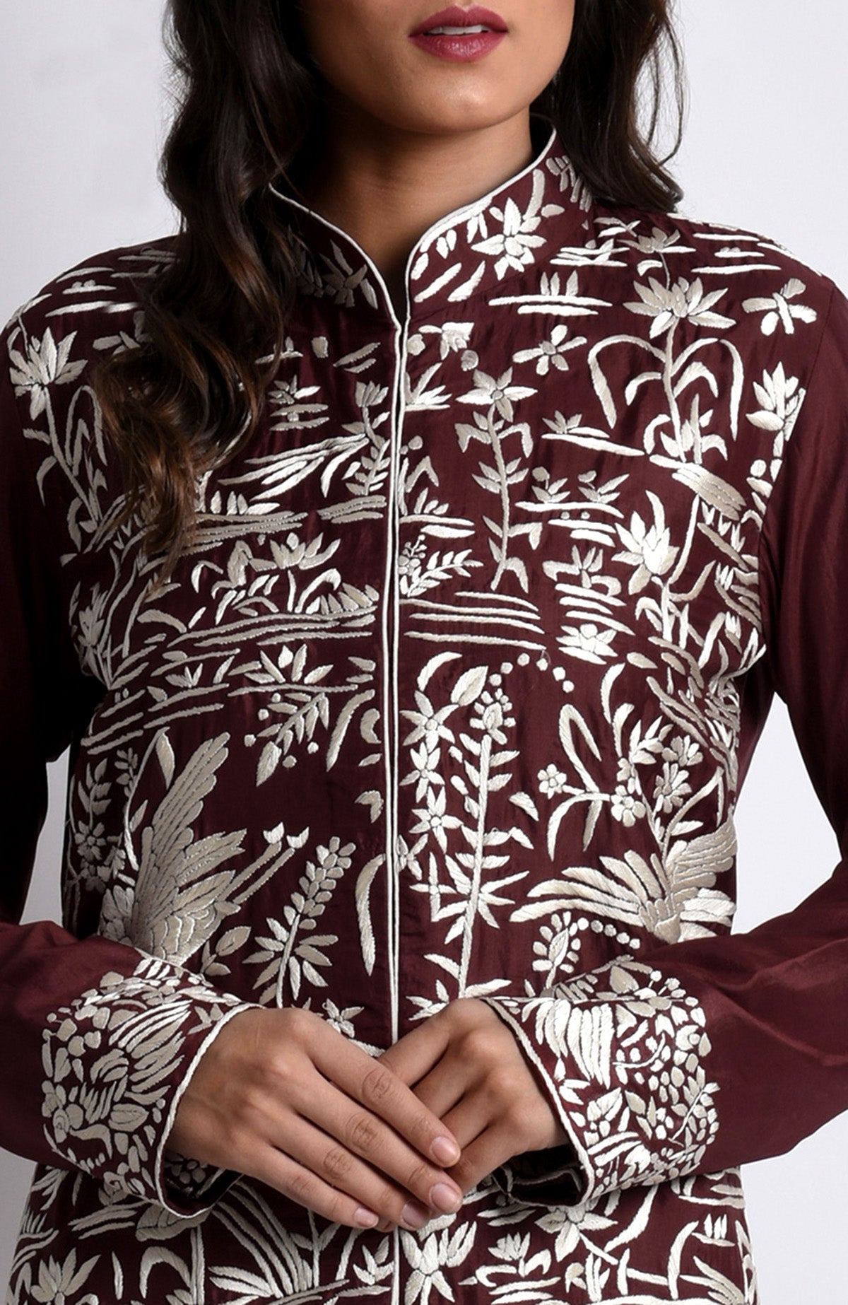 Maroon Parsi Gara embroidered jacket with ivory floral and crane-bird patterns.