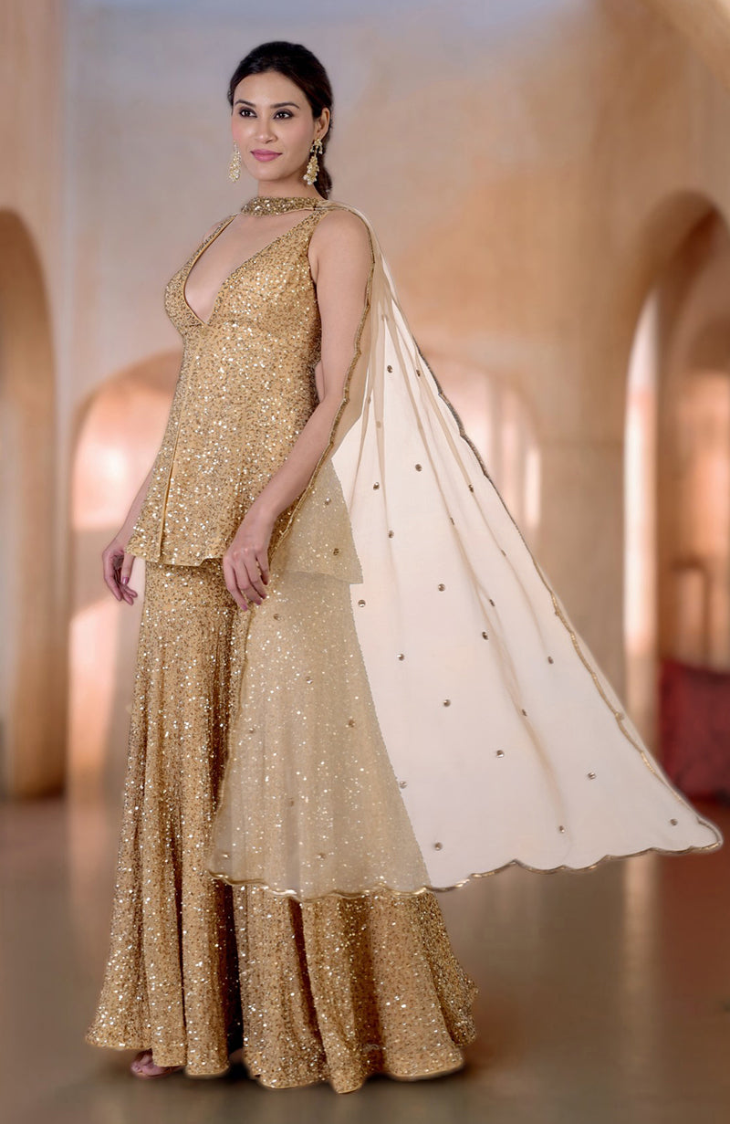 Gold sequin and bead embroidered sharara set with a plunging neckline and cape.
