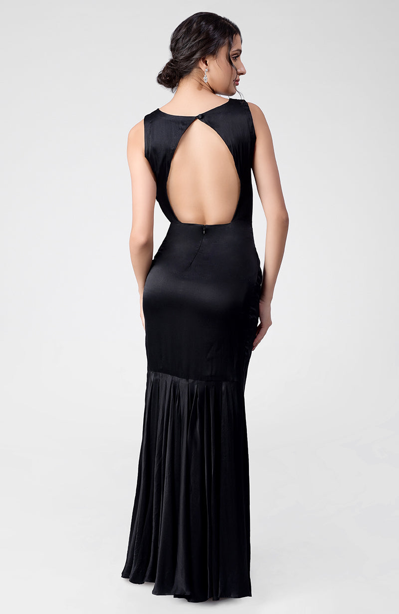 Black silk satin crepe gown with boat neckline and pleated open back detail.