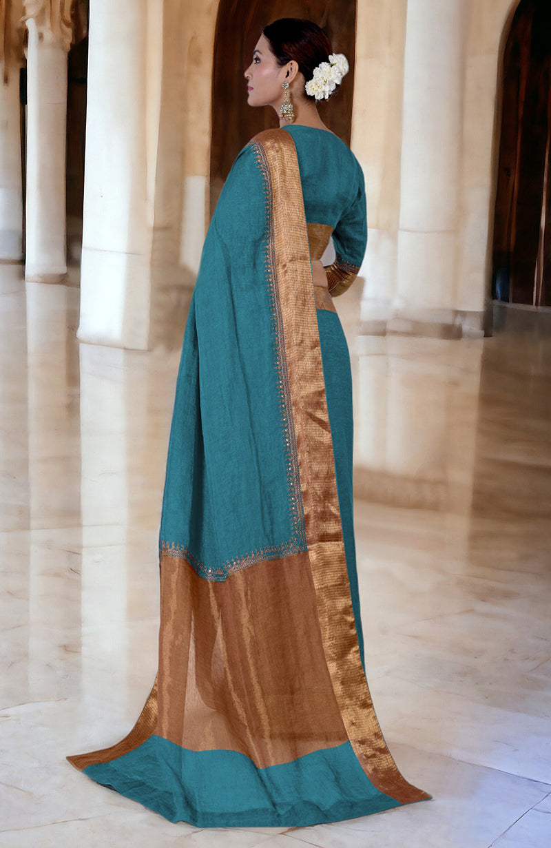 Mosaic blue linen saree with gold marori embroidered borders and a matching blouse.