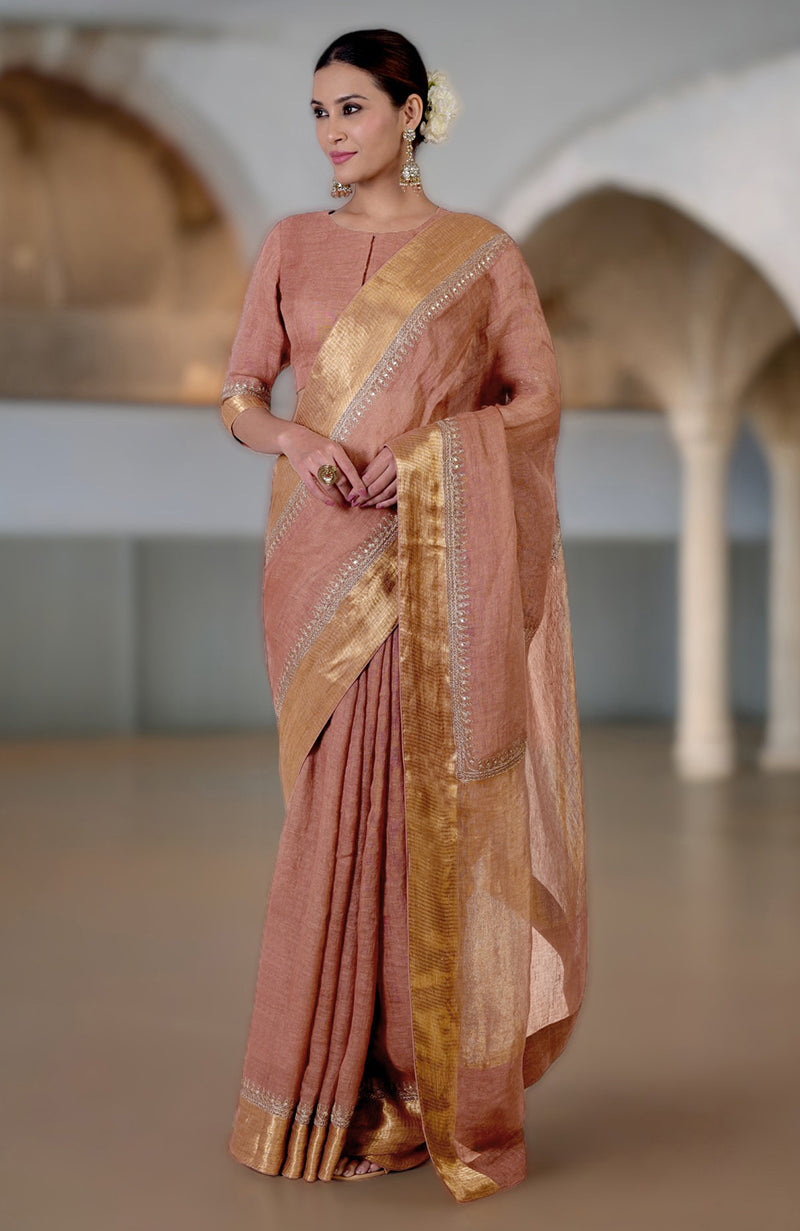 A woman models a chutney marori embroidered linen saree with a gold border.