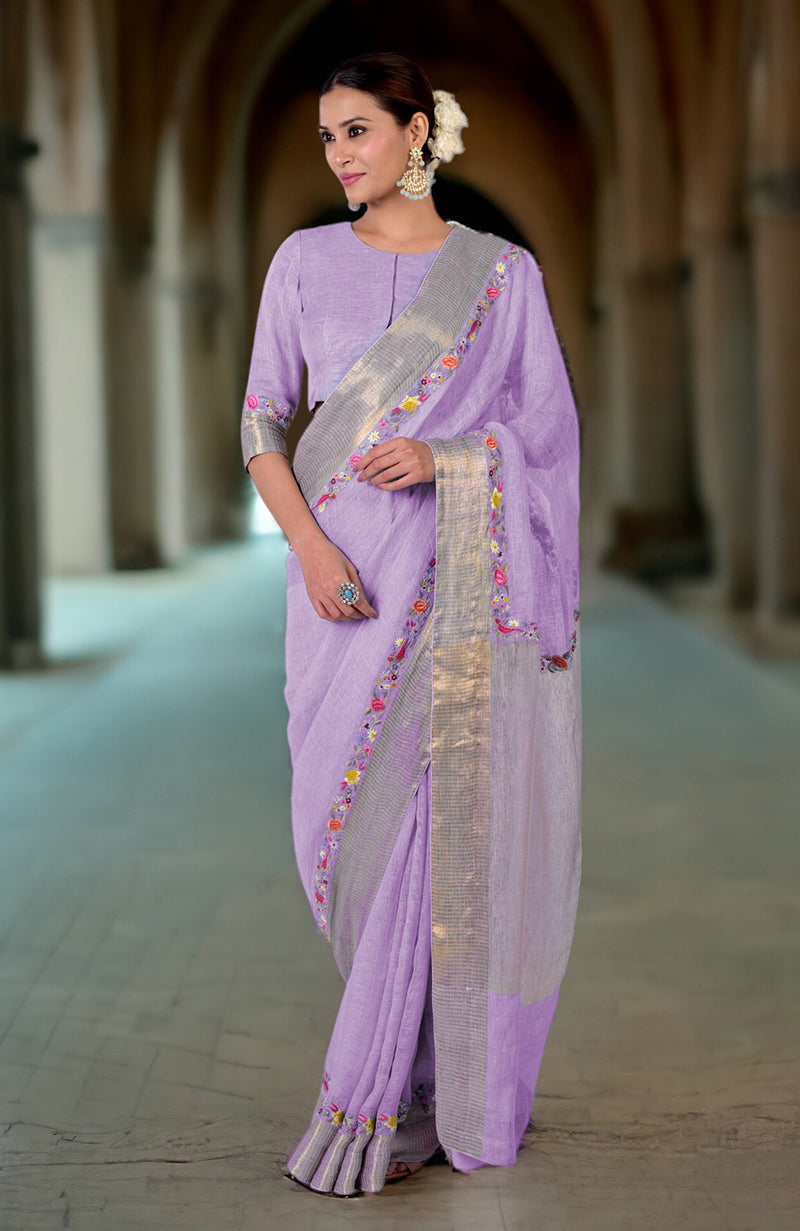 A woman models a lilac linen saree with Parsi Gara embroidery and zari details.