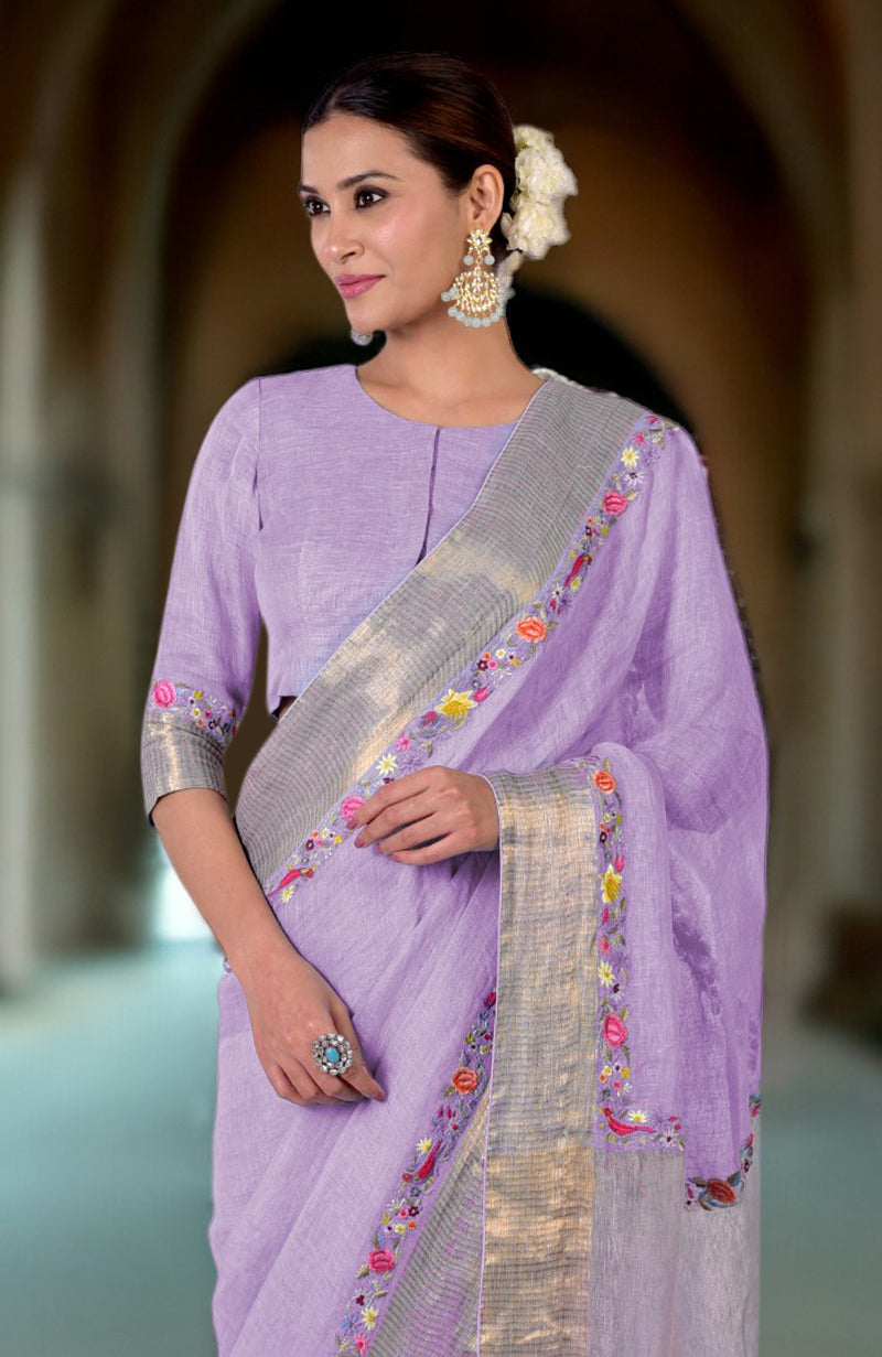 A woman models a lilac linen saree with Parsi Gara embroidery and zari details.