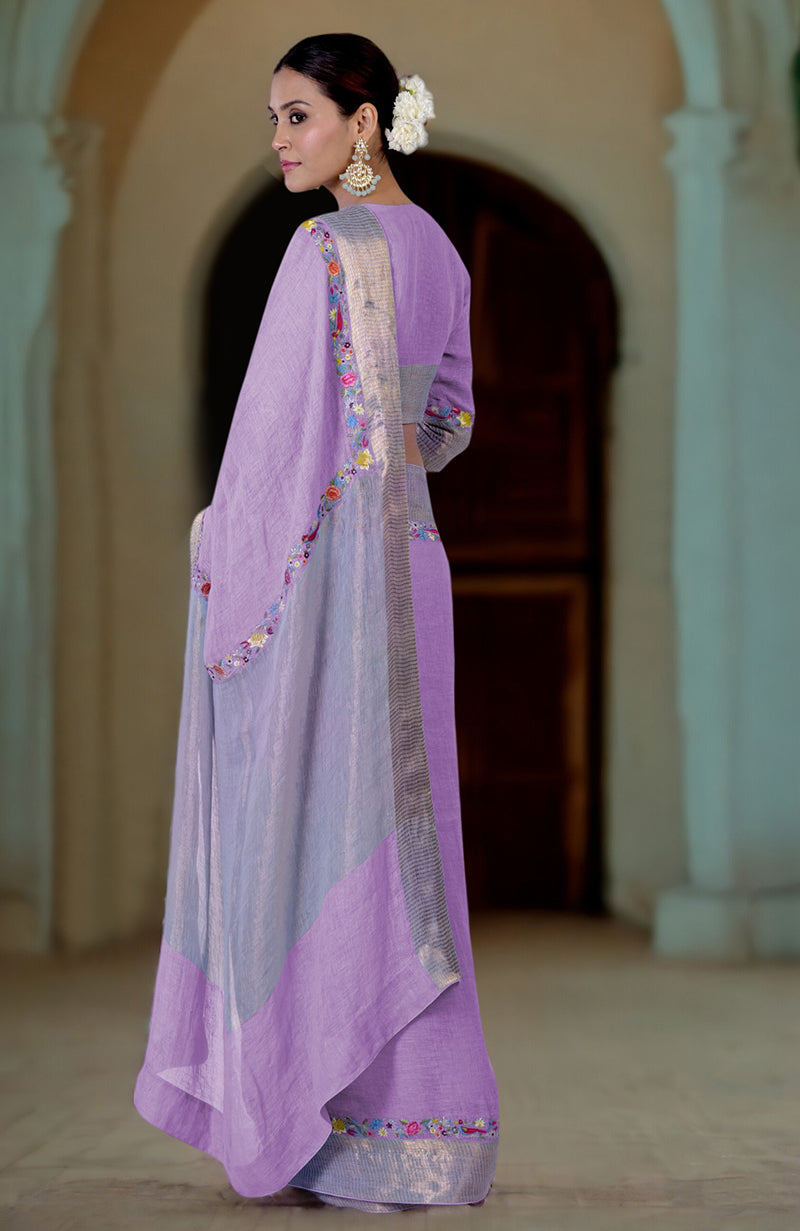 A woman models a lilac linen saree with Parsi Gara embroidery and zari details.