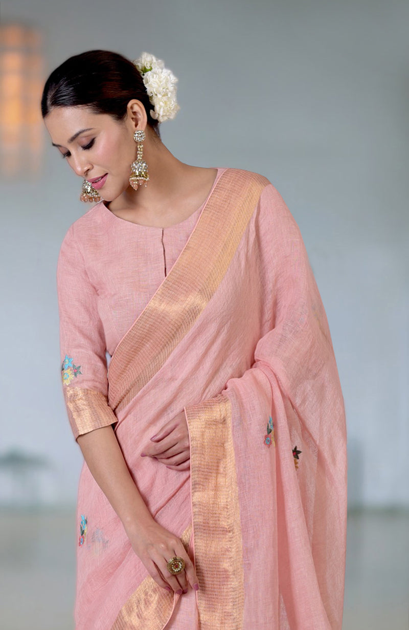 Pink linen saree with Kashidakari embroidery, gold zari border, and matching blouse.