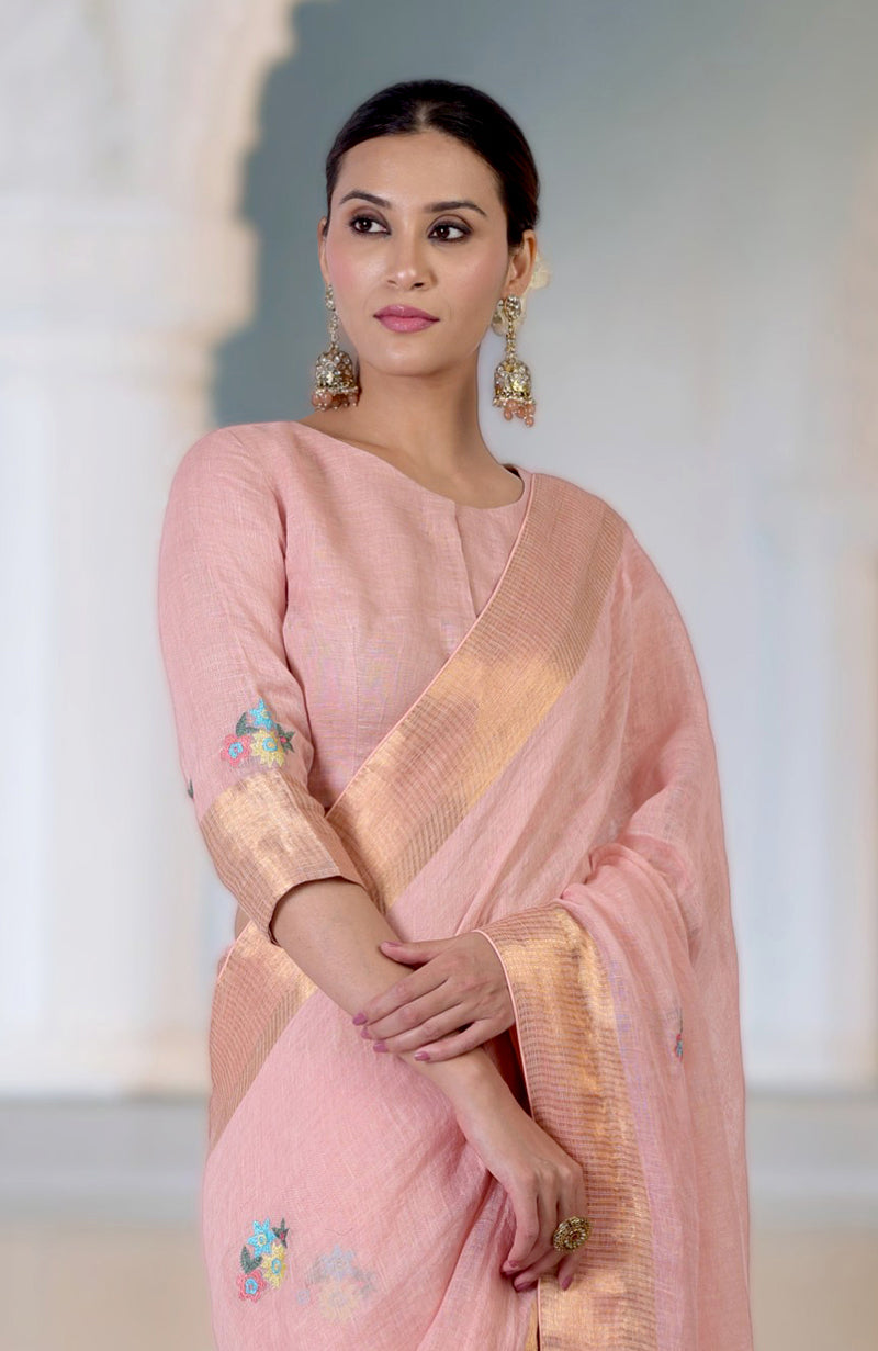 Pink linen saree with Kashidakari embroidery and gold zari details.