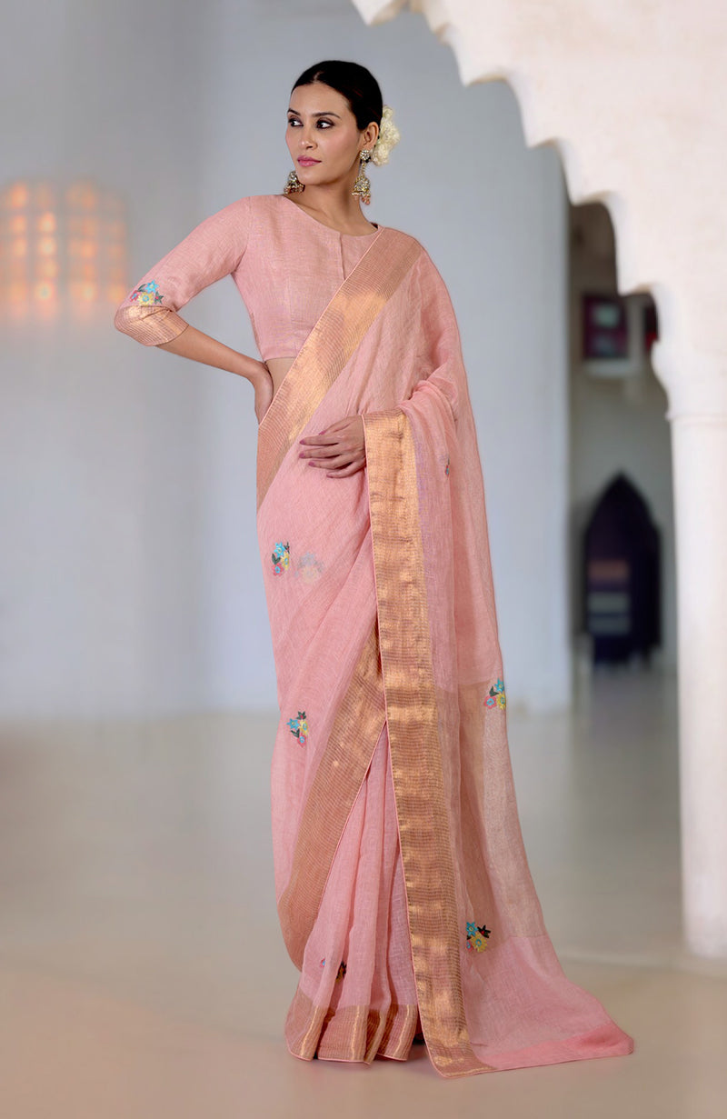 Pink linen saree with Kashidakari embroidery and gold zari border.