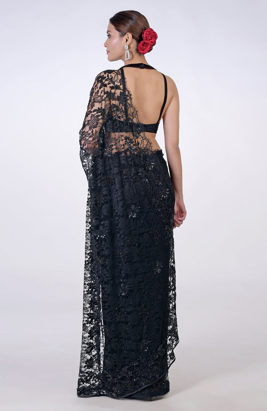 A woman models a black French Chantilly lace saree with hand embroidery.