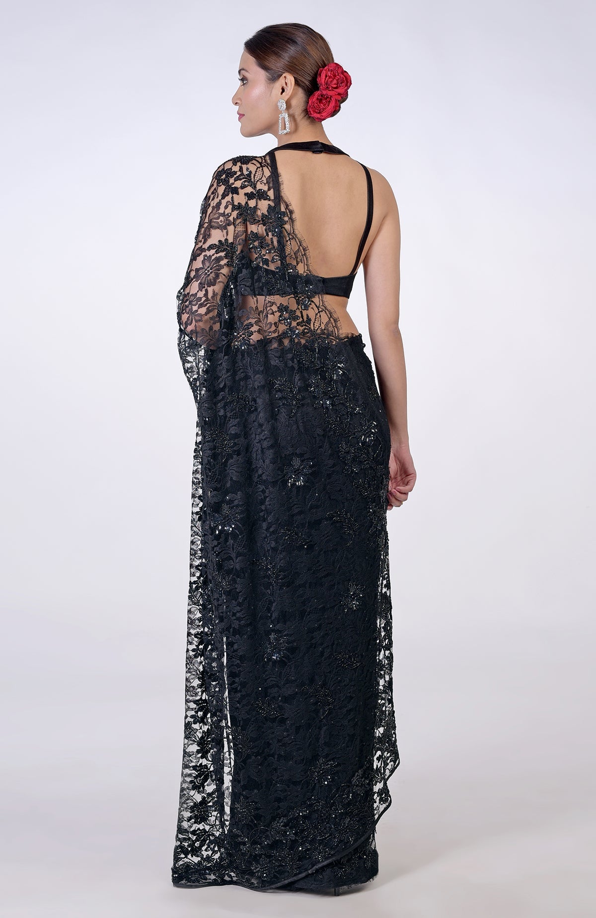 A woman models a black French Chantilly lace saree with hand embroidery.