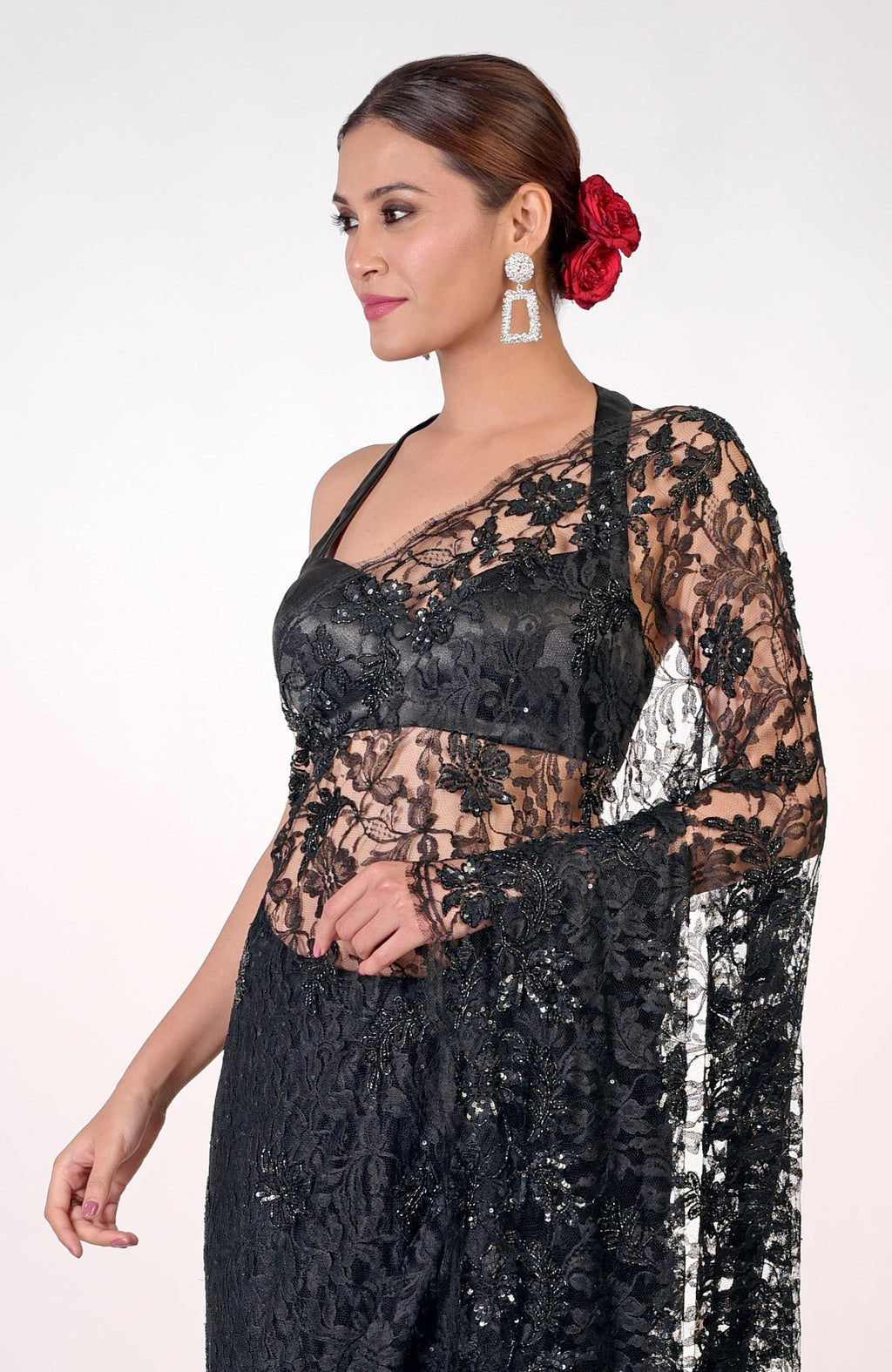A woman models a black French Chantilly lace hand-embroidered saree.