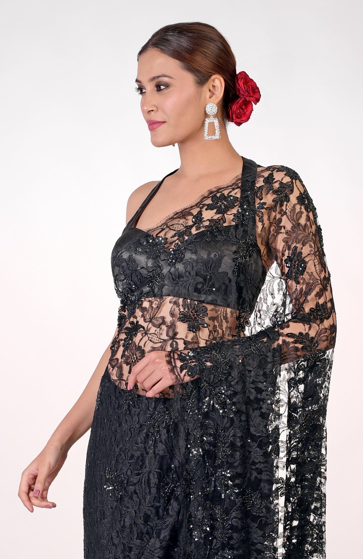 A woman models a black French Chantilly lace hand-embroidered saree.