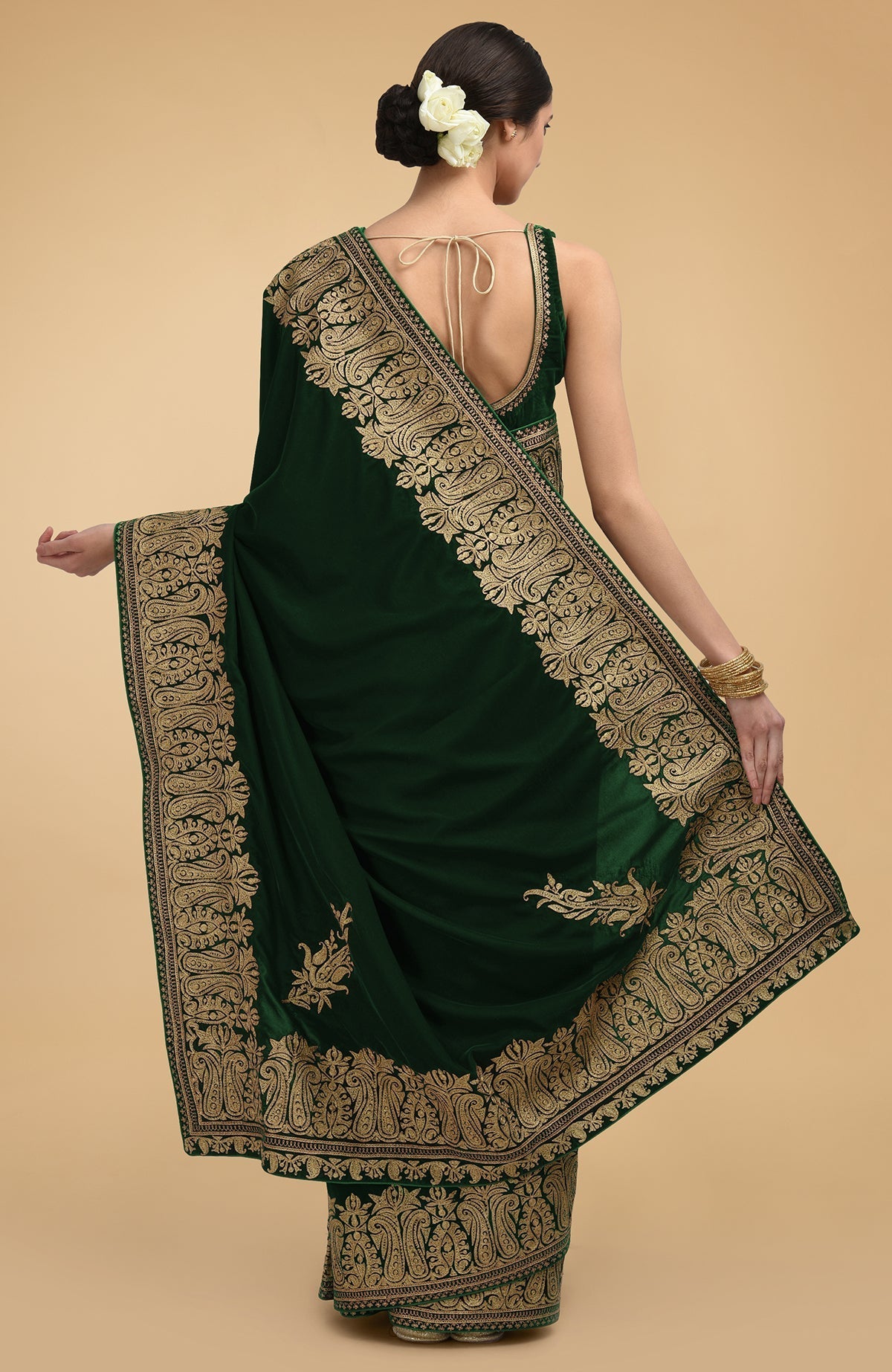 Bottle green velvet saree with gold Kashmiri tilla aari embroidery on borders and pallav.