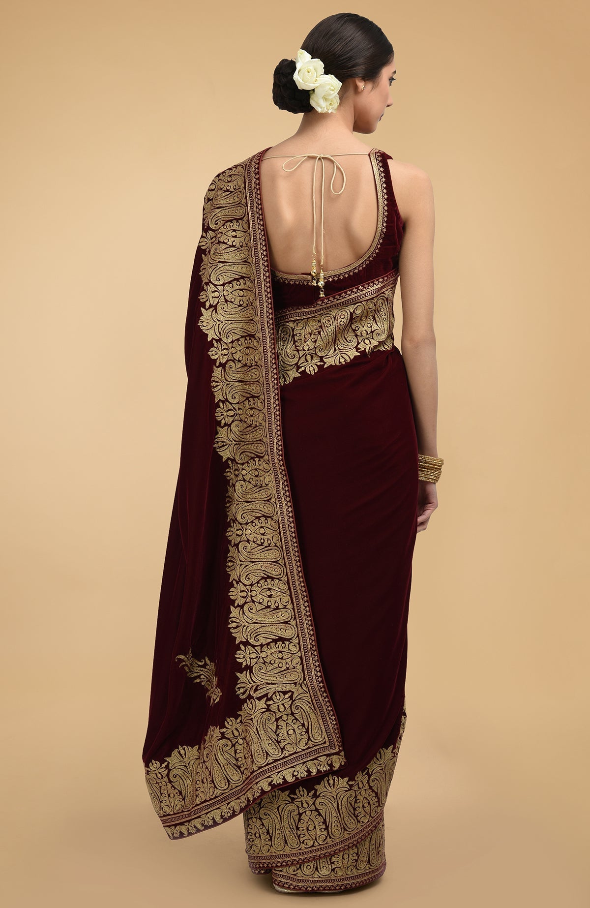 Burgundy velvet saree with gold tilla aari embroidery and a deep back blouse.