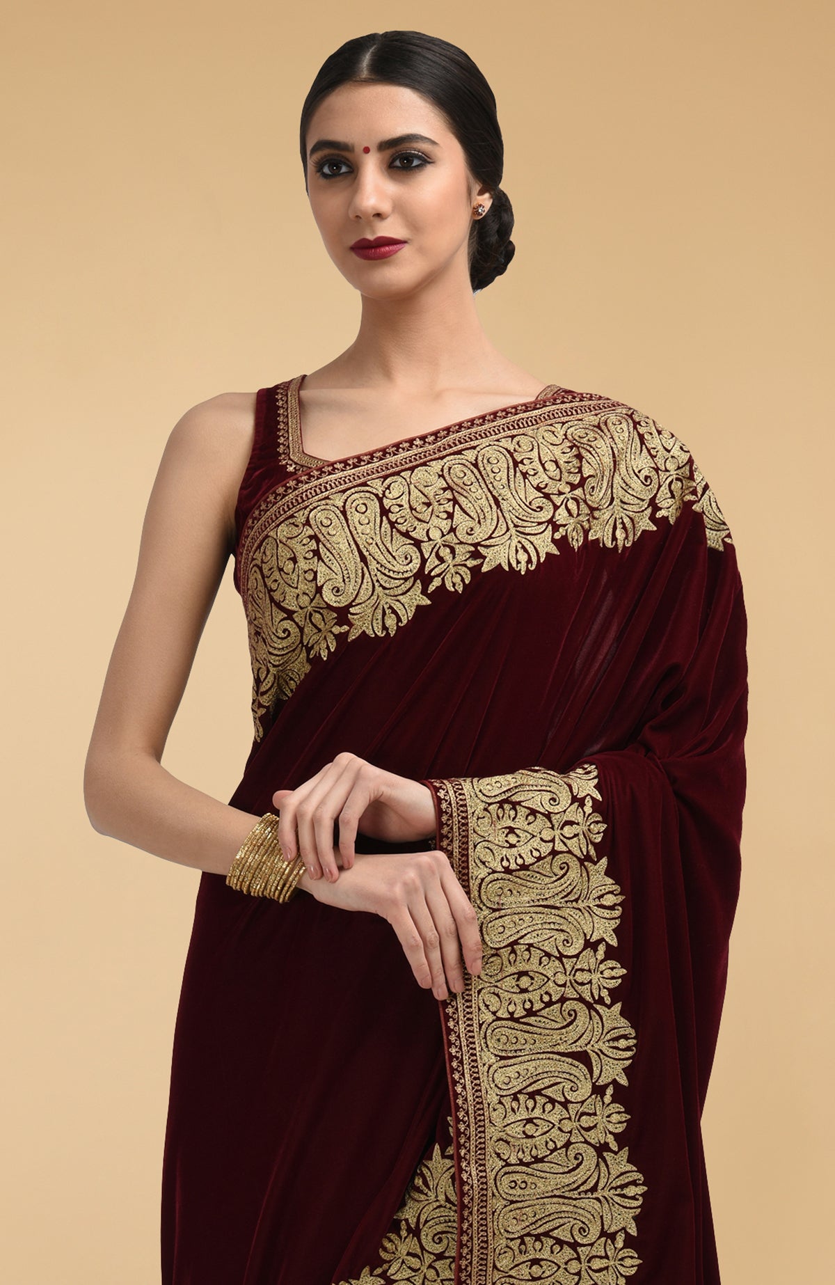 Burgundy velvet saree with gold tilla aari embroidery and a matching blouse.