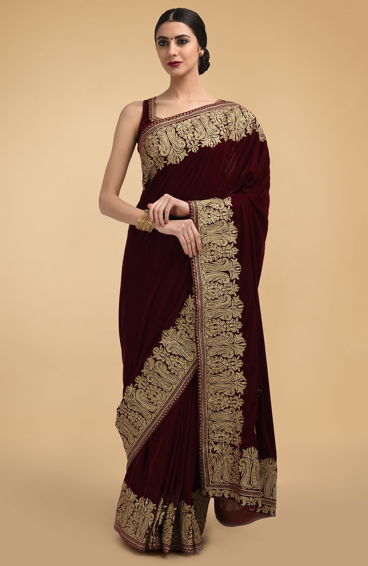 Bottle green velvet saree with gold Kashmiri tilla aari embroidery on borders and pallav.