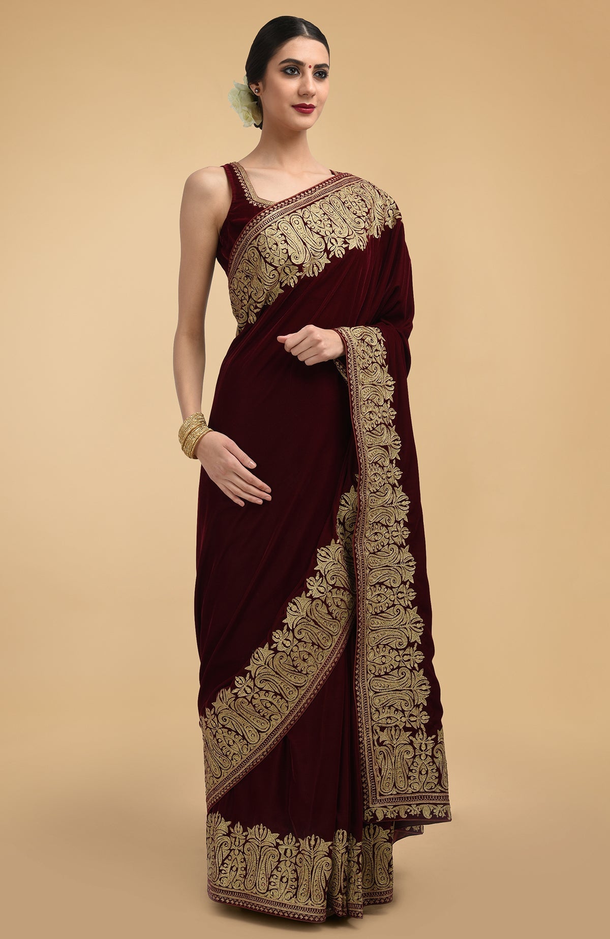 Burgundy velvet saree with gold tilla aari embroidery and a matching blouse.
