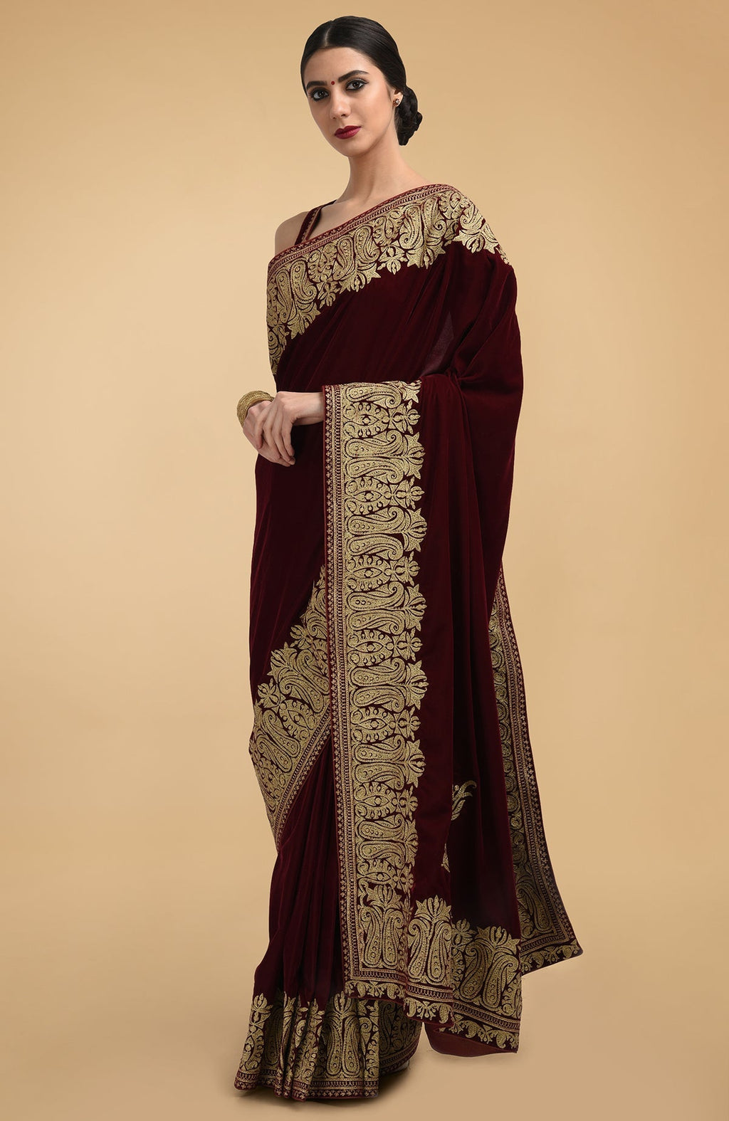 Burgundy velvet saree with gold tilla aari embroidery.