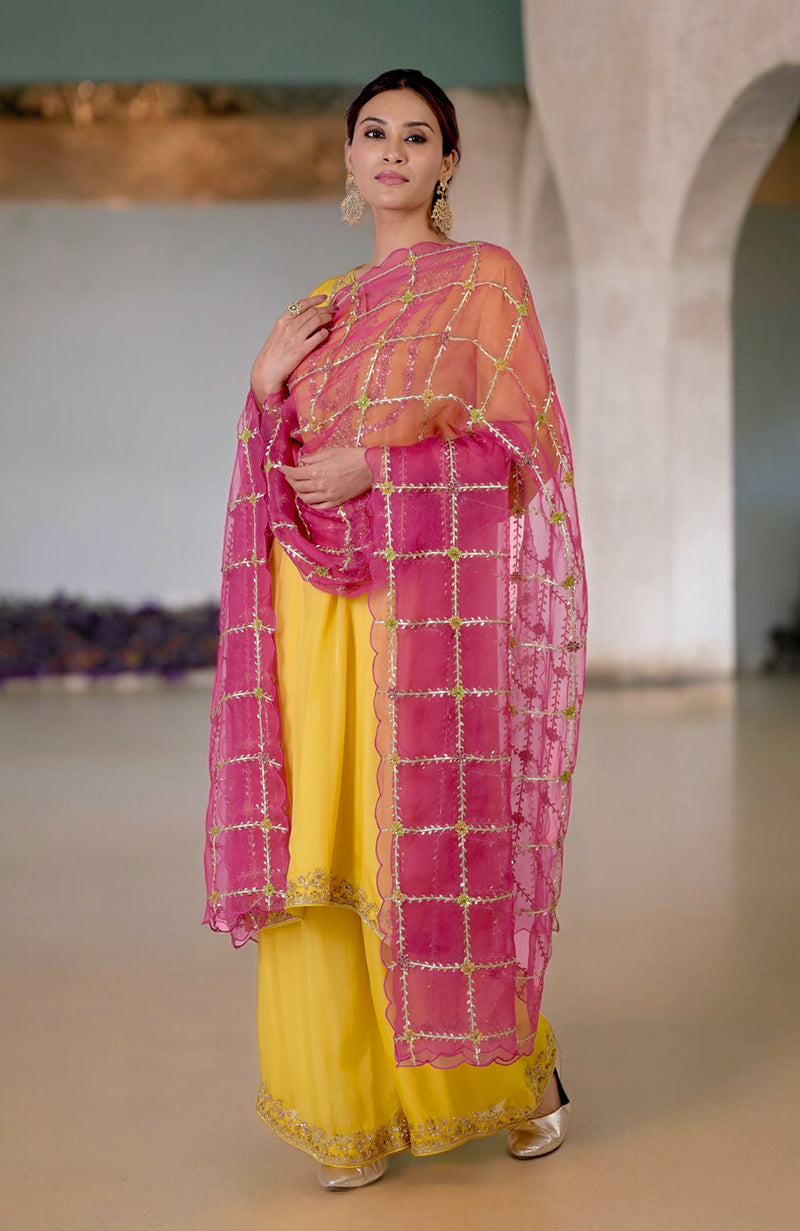 Buttercup yellow suit with fuchsia dupatta featuring gota and zardozi embroidery.