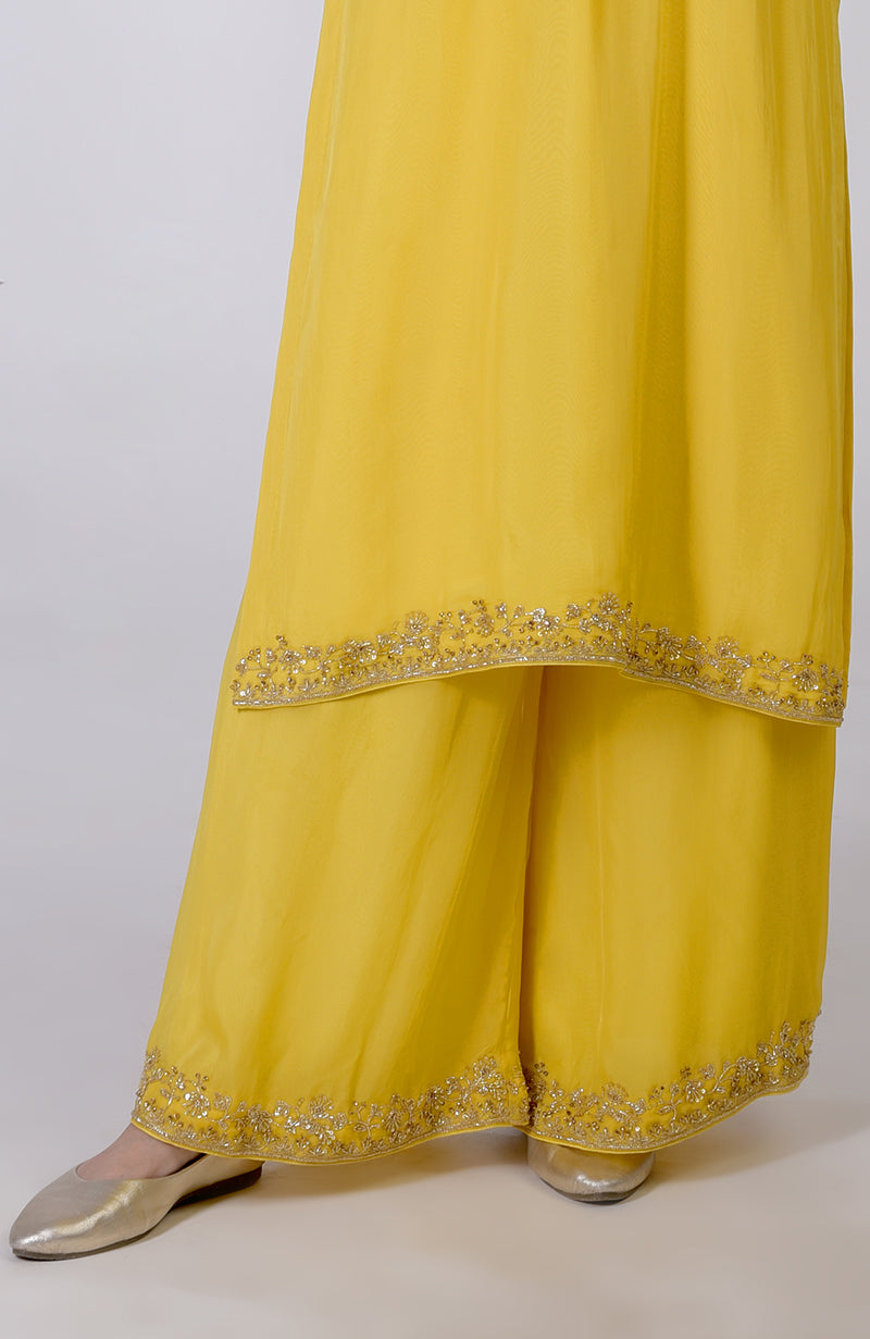 Buttercup yellow zardozi hand-embroidered suit set with gold embellishments and matching shoes.
