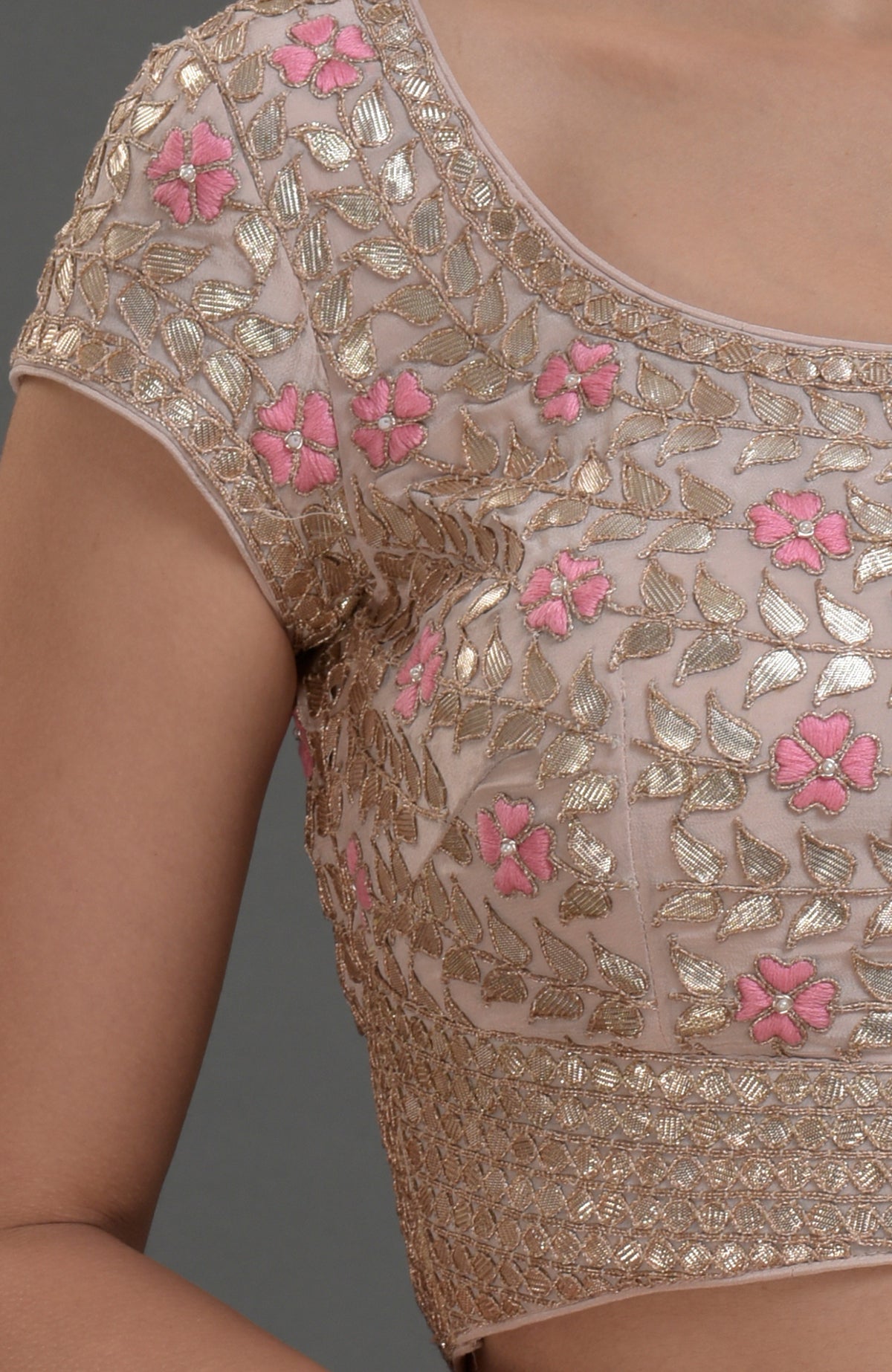 Nude pink blouse with intricate rose gold gota patti and floral hand embroidery.