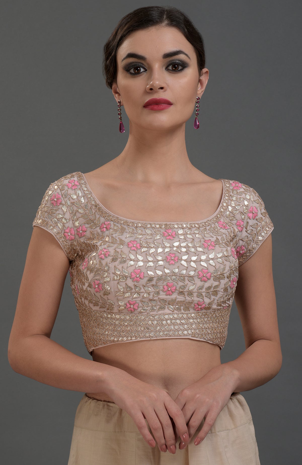 A woman models a nude pink hand-embroidered gota patti pure crepe saree and blouse.