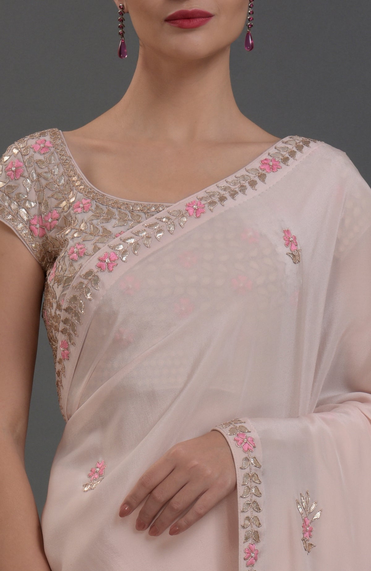 Nude pink pure crepe saree with rose gold gota patti and floral hand embroidery.