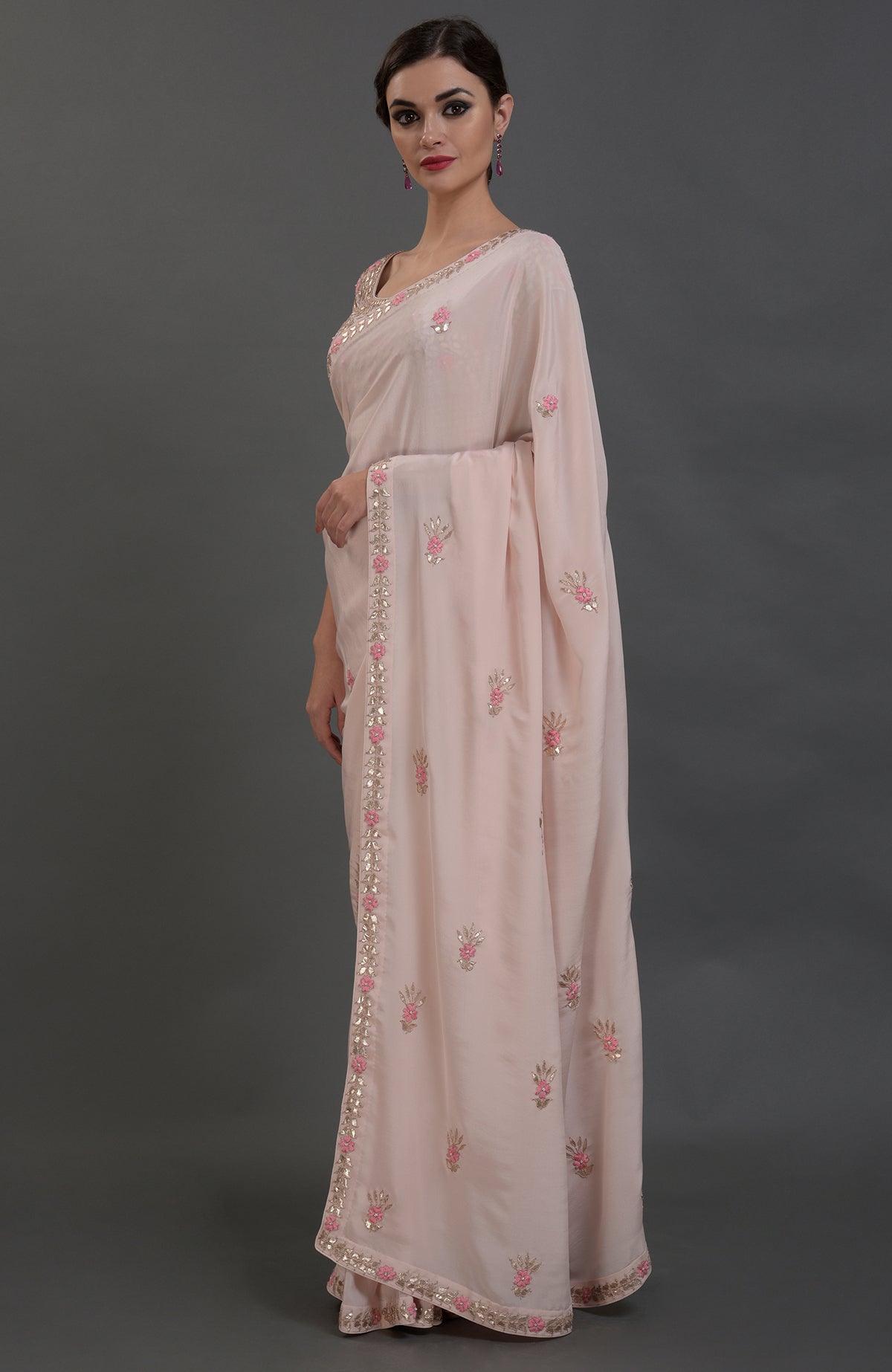 Nude pink pure crepe saree with rose gold gota patti and floral hand embroidery.