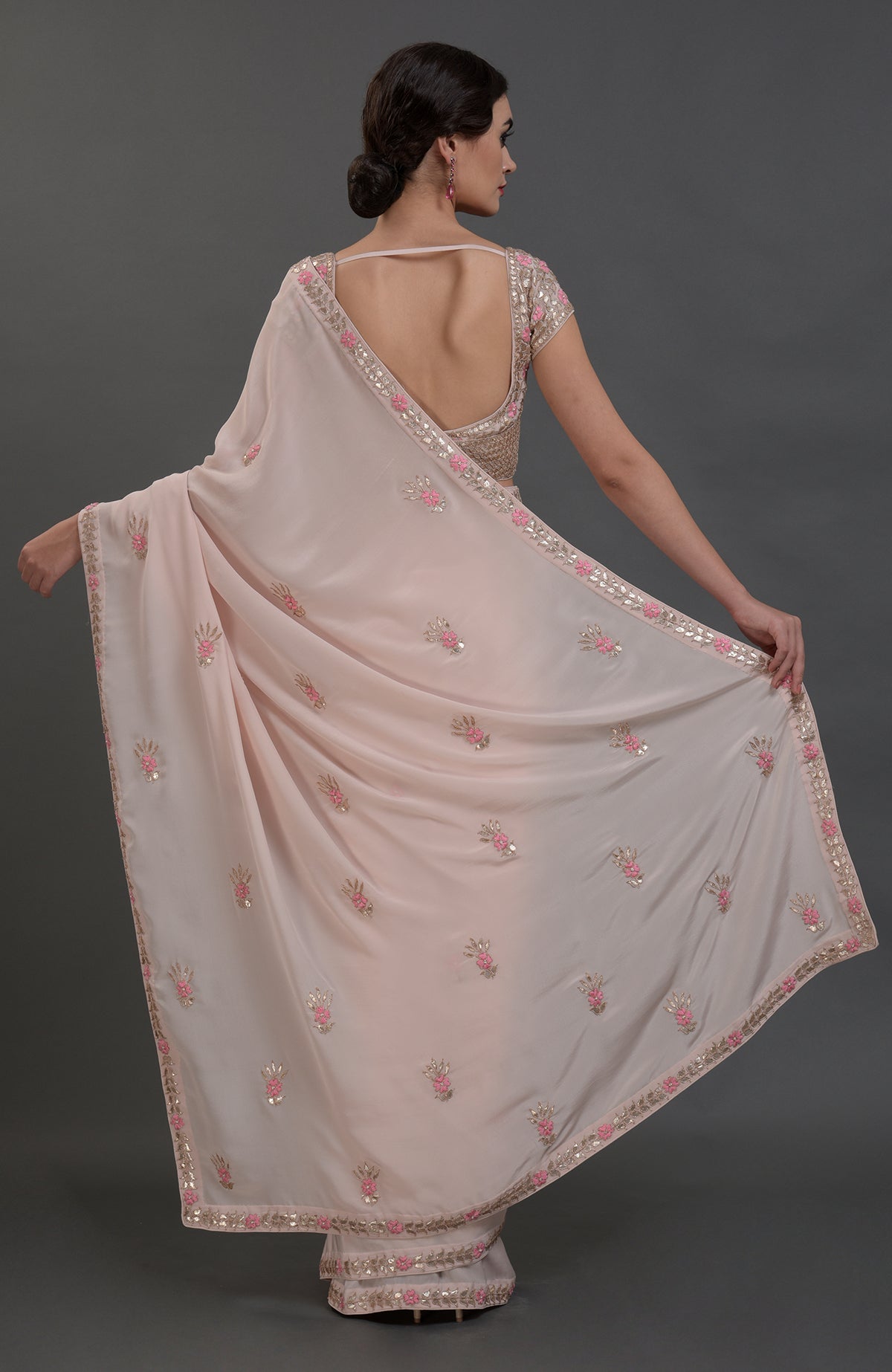 Nude pink pure crepe saree with rose gold gota patti and floral hand embroidery.
