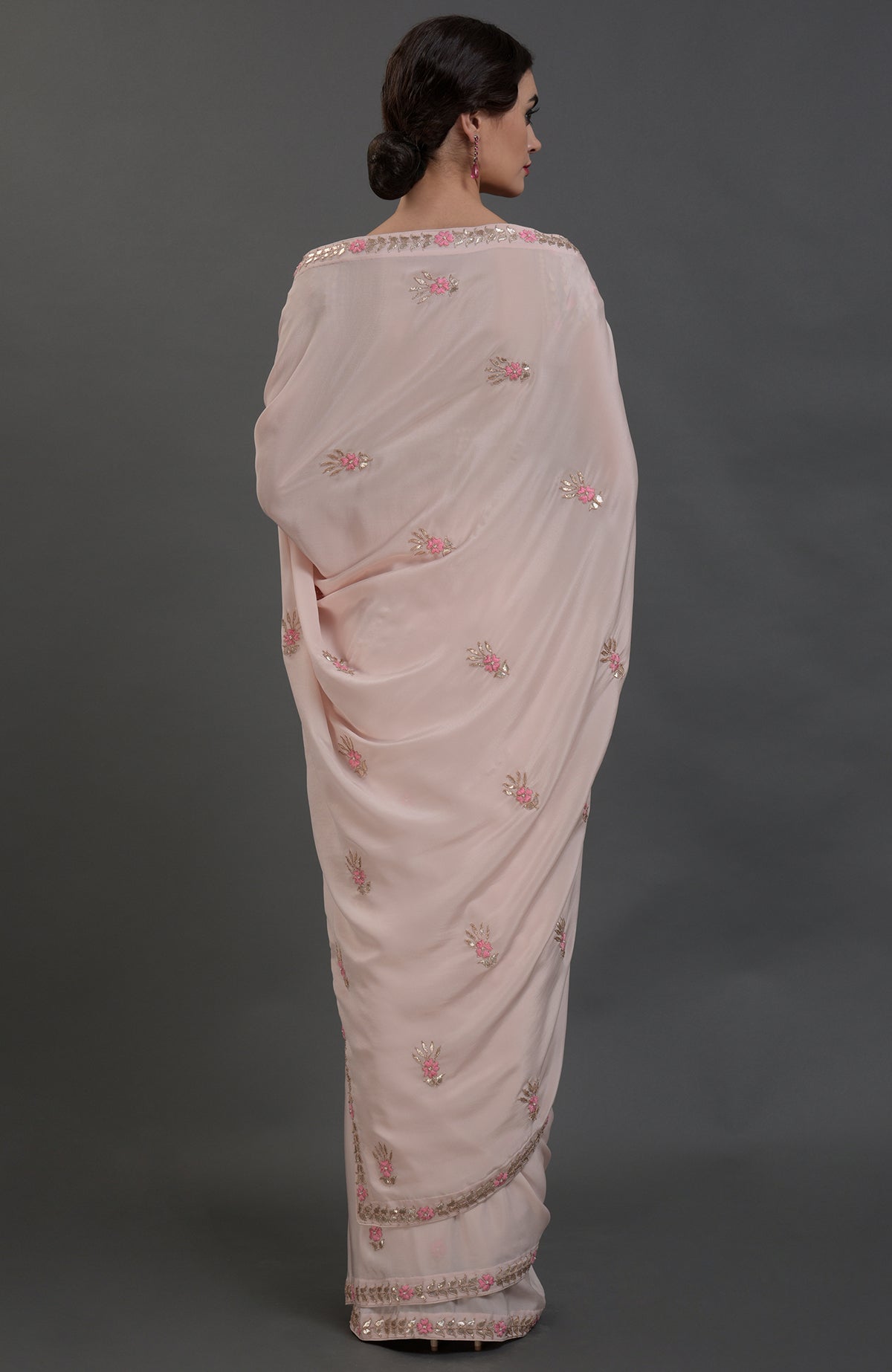 Nude pink pure crepe saree with rose gold gota patti and floral hand embroidery.
