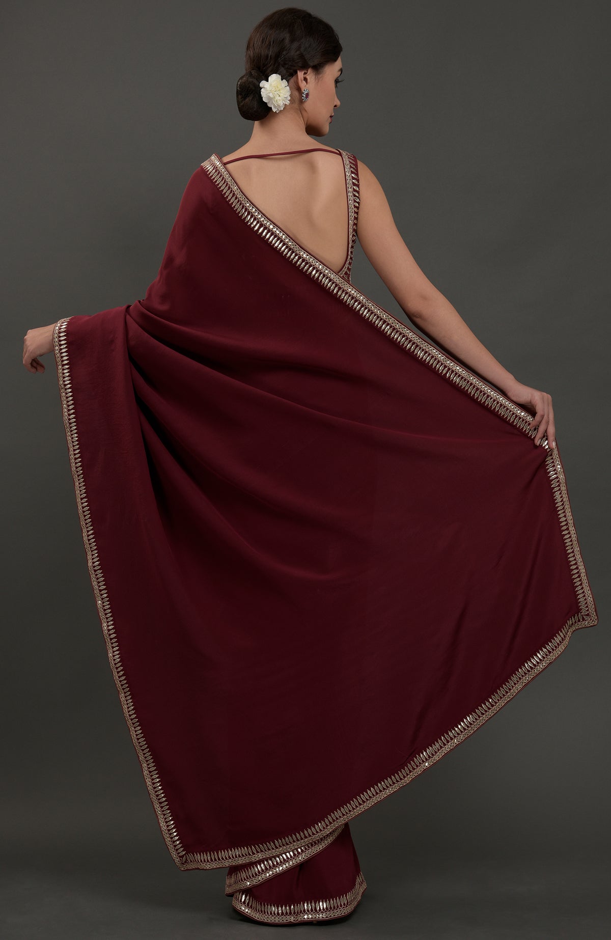 Burgundy crepe saree with silvery gold gota patti embroidery and a deep back blouse.