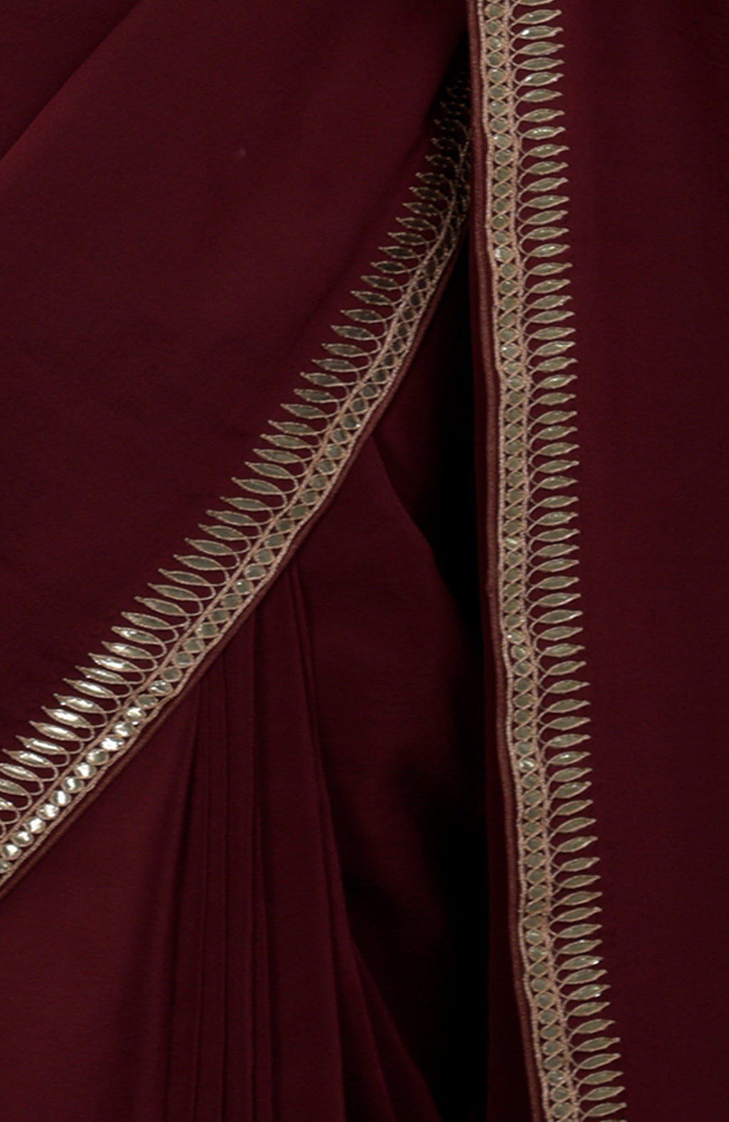 Burgundy crepe saree with silvery gold gota patti embroidery on the borders.