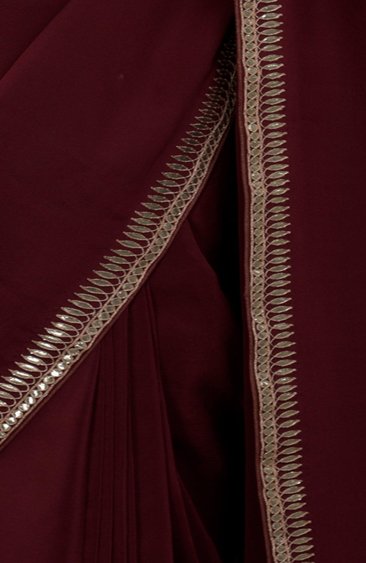 Burgundy crepe saree with silvery gold gota patti embroidery on the borders.