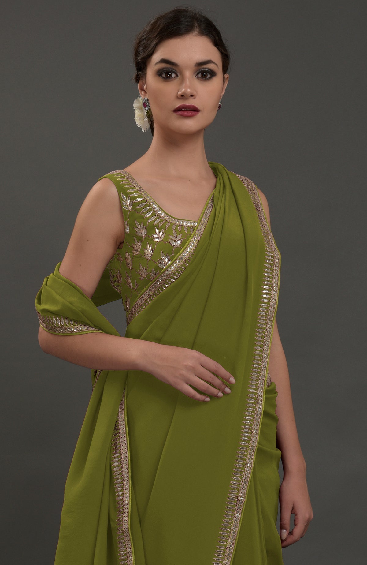 An avocado green embroidered gota patti saree with a matching blouse.
