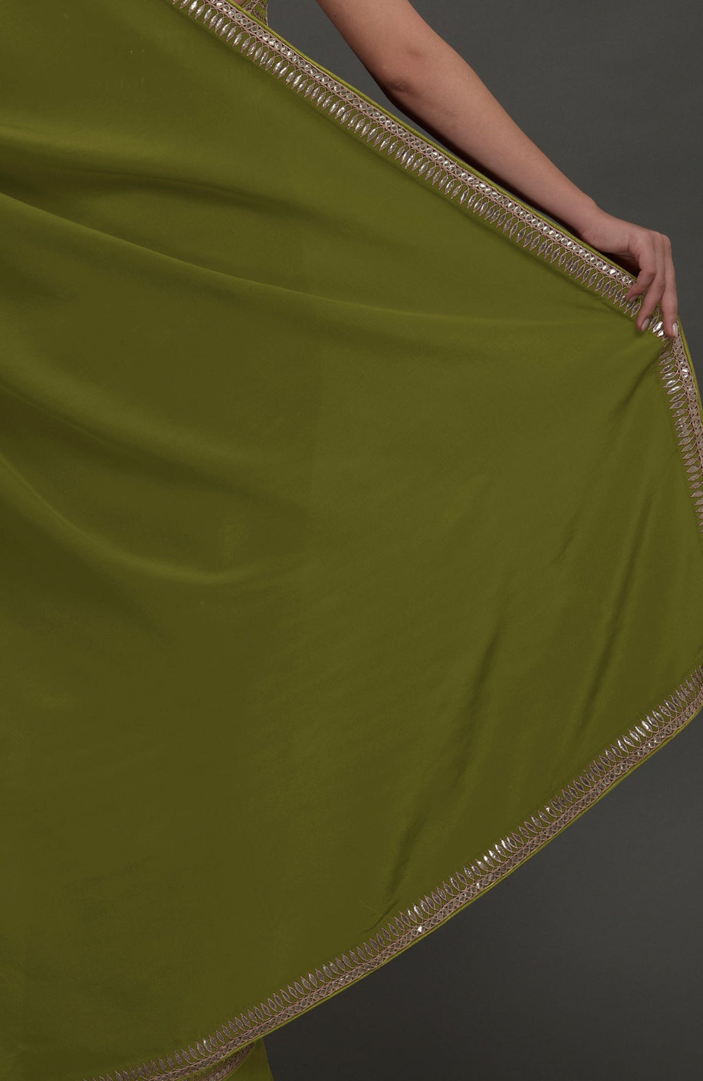 Avocado green crepe saree with silvery gold gota patti embroidery on the borders.