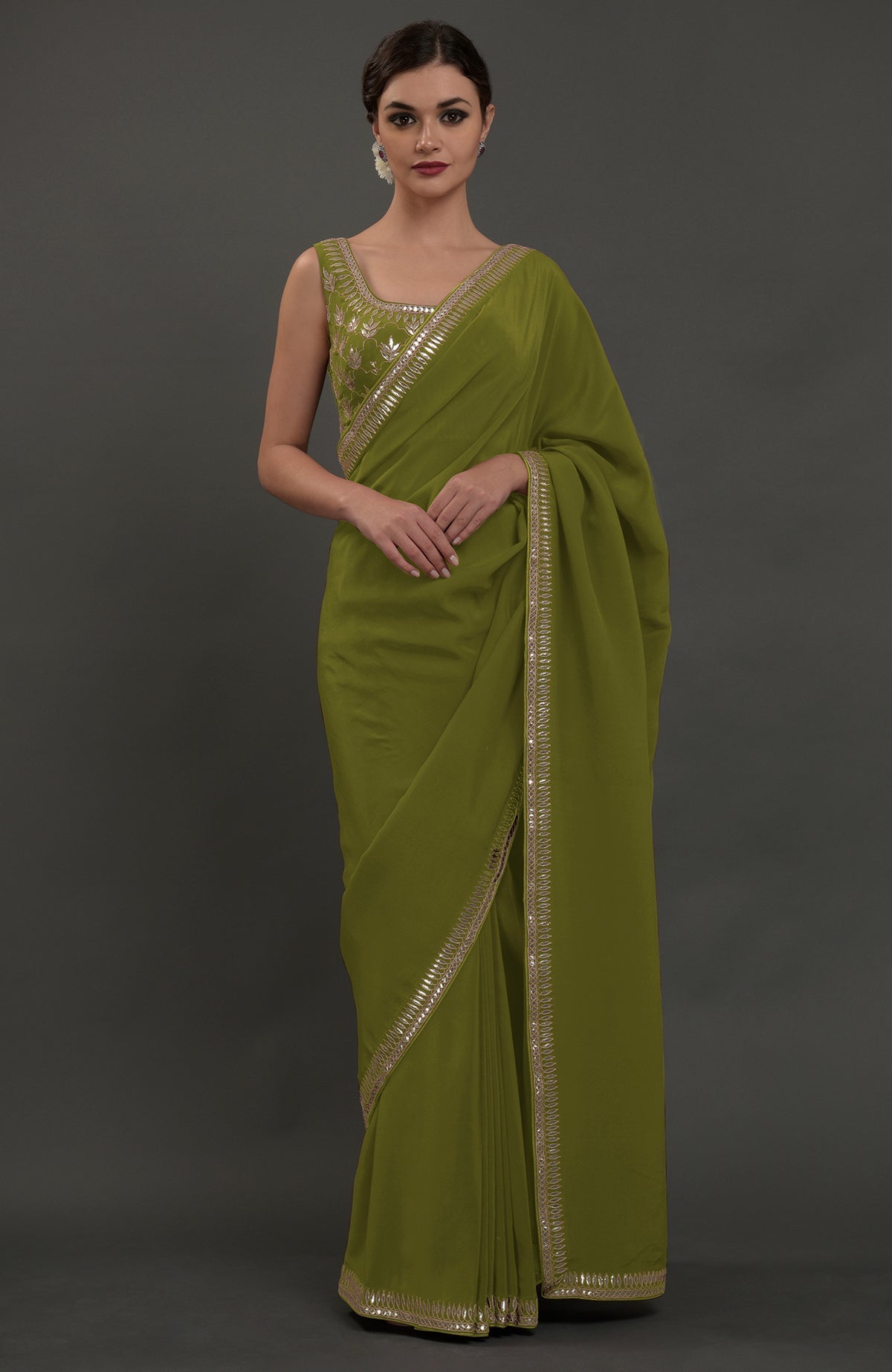Woman in an oceanside blue embroidered gota patti saree.