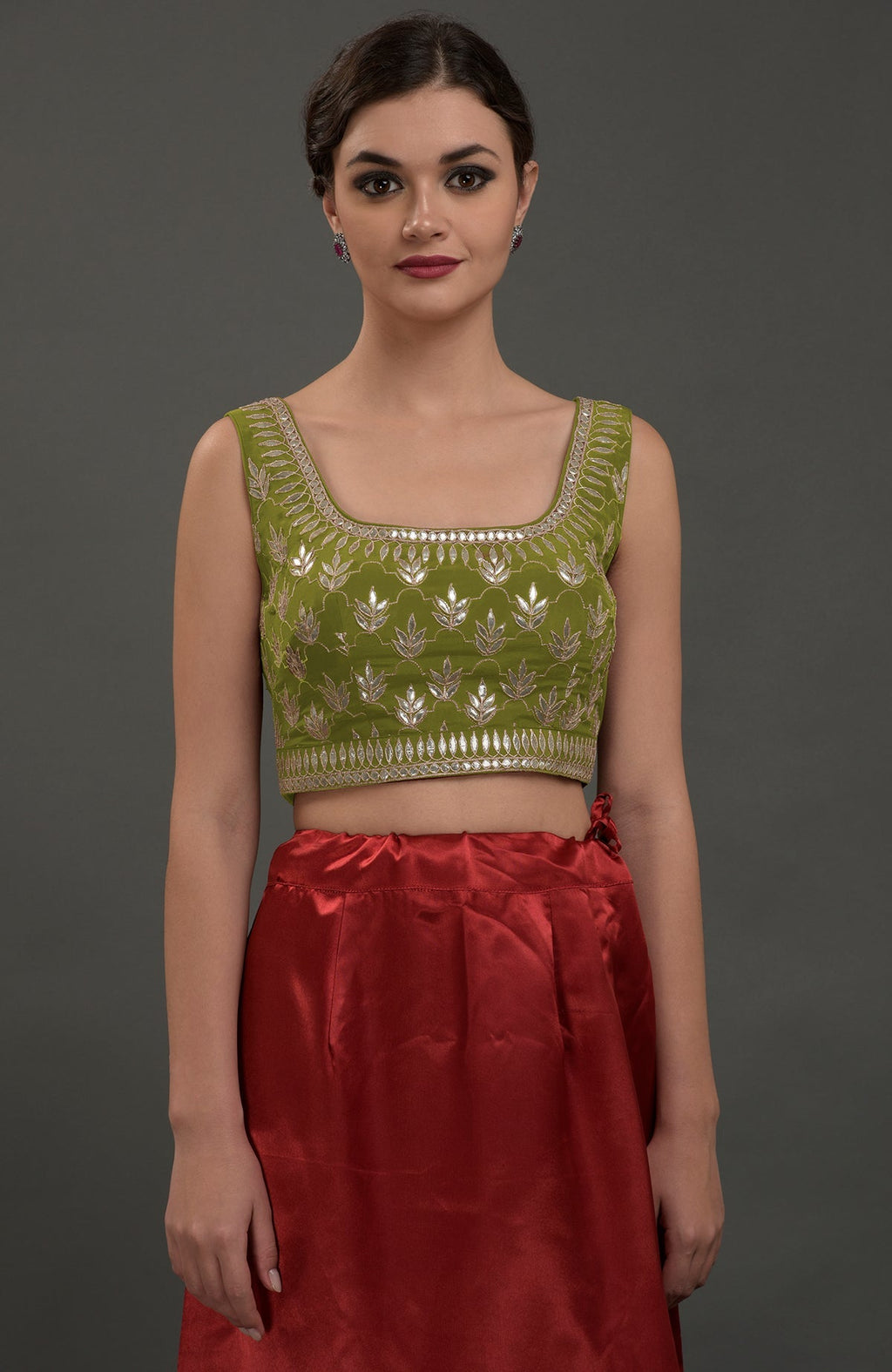 Avocado green embroidered gota patti saree with a red skirt.