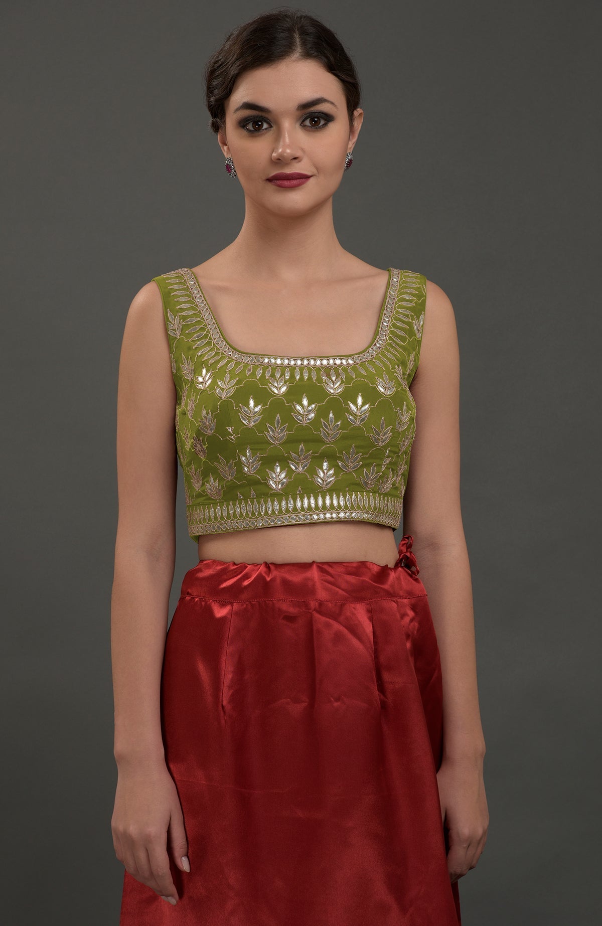 Avocado green embroidered gota patti saree with a red skirt.