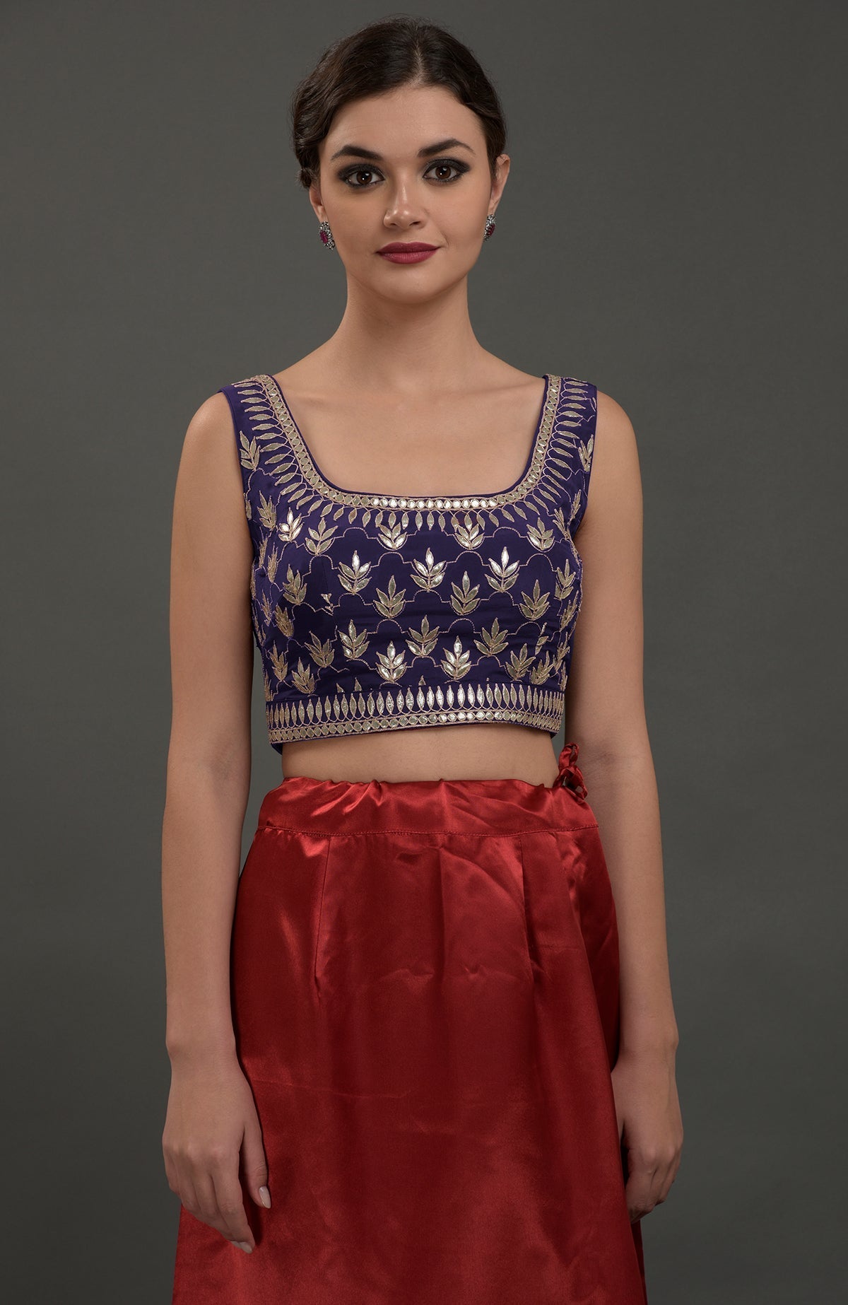 Oceanside blue hand embroidered gota patti blouse paired with a red skirt.