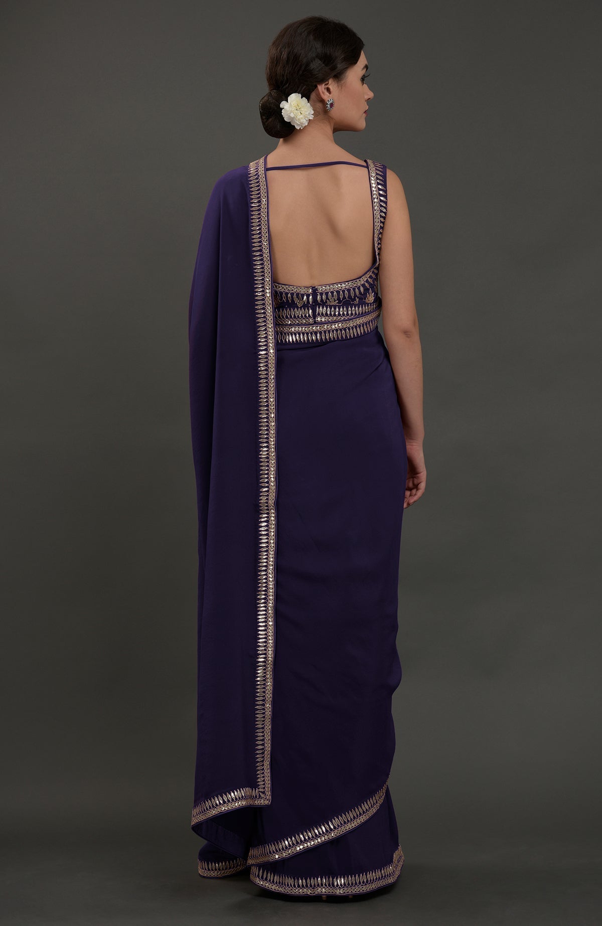 A woman from behind models an eclipse blue embroidered gota patti saree.