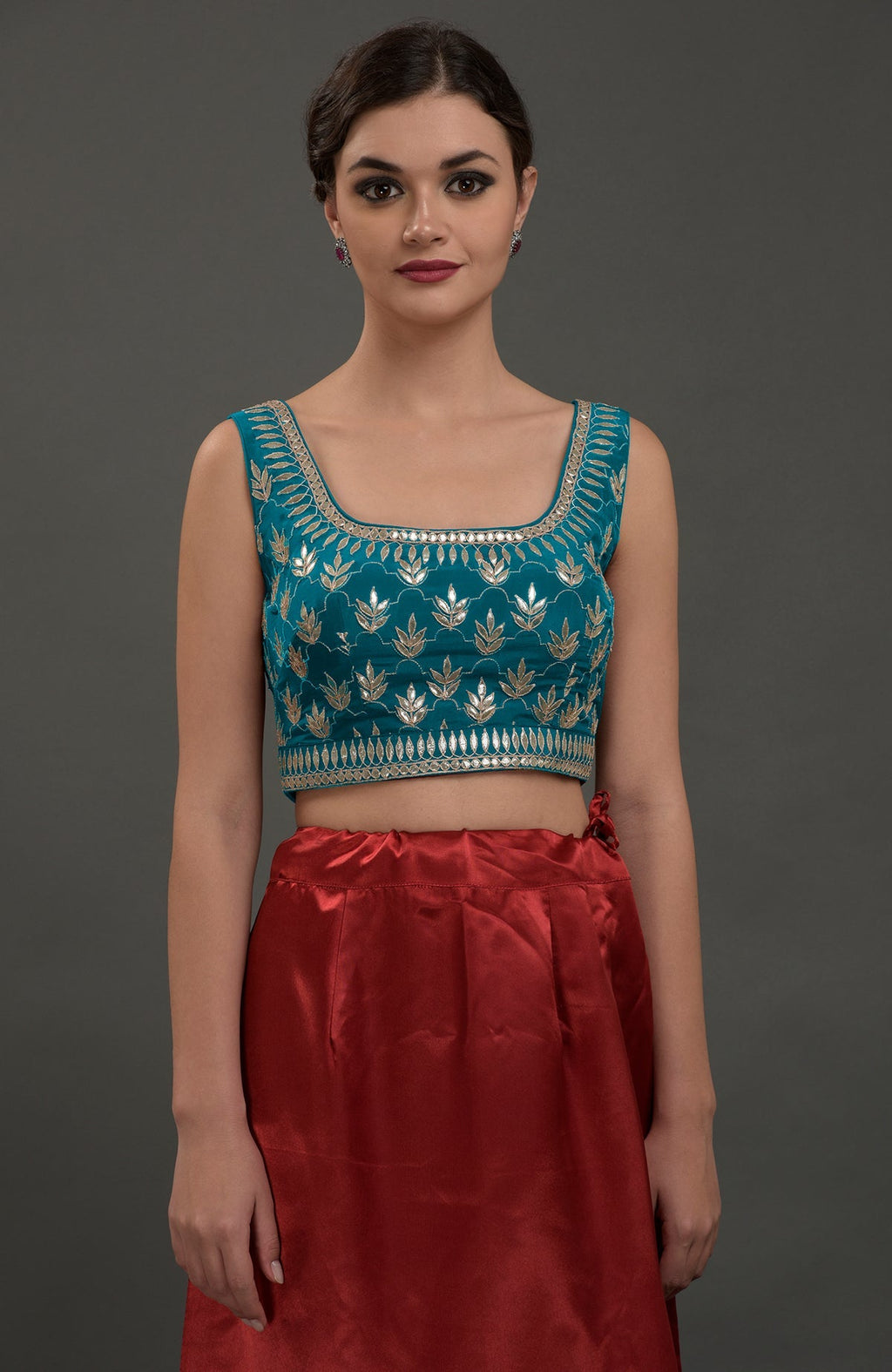A woman models an oceanside blue embroidered gota patti saree and blouse.