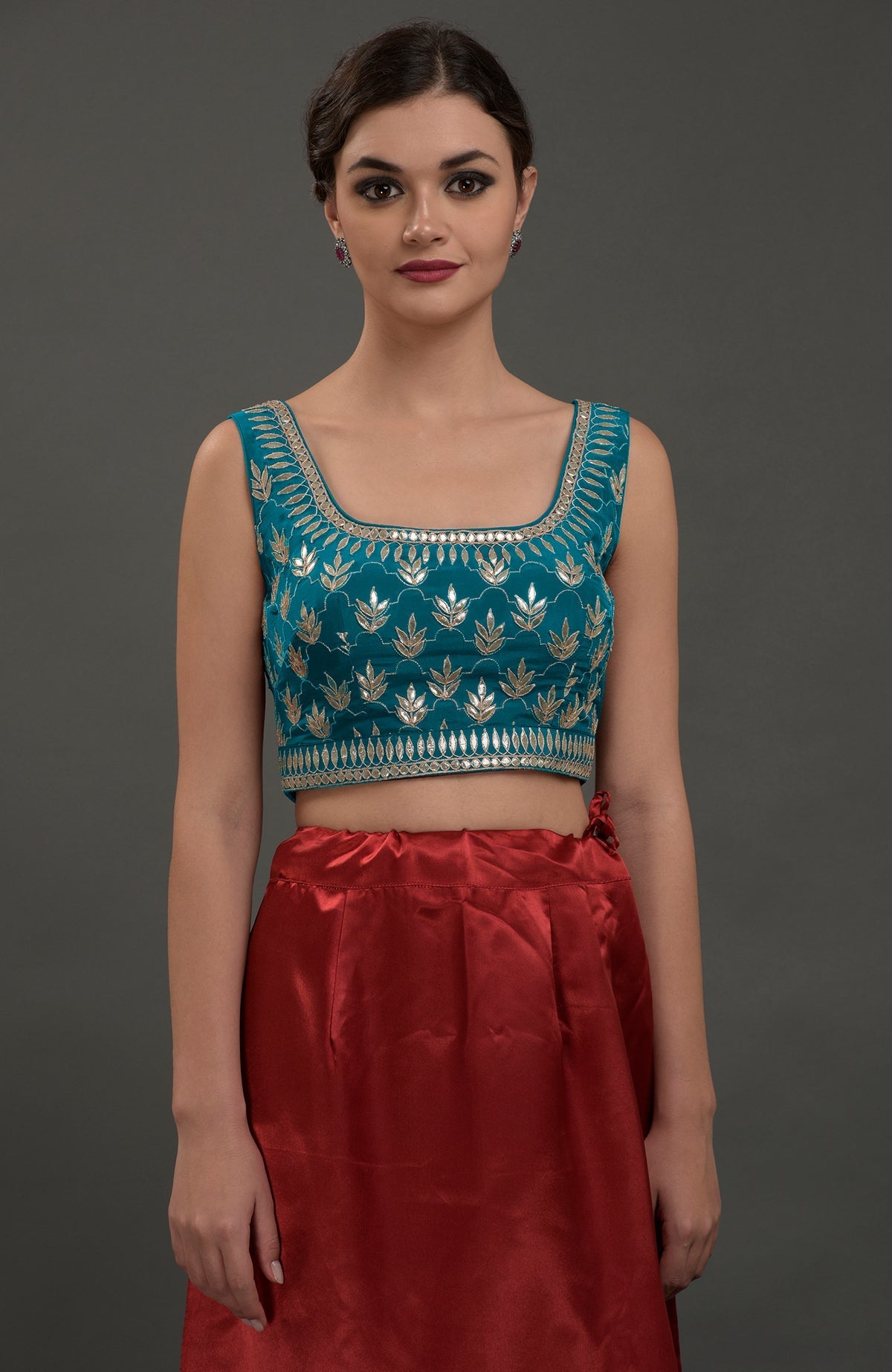 A woman models an oceanside blue embroidered gota patti saree and blouse.