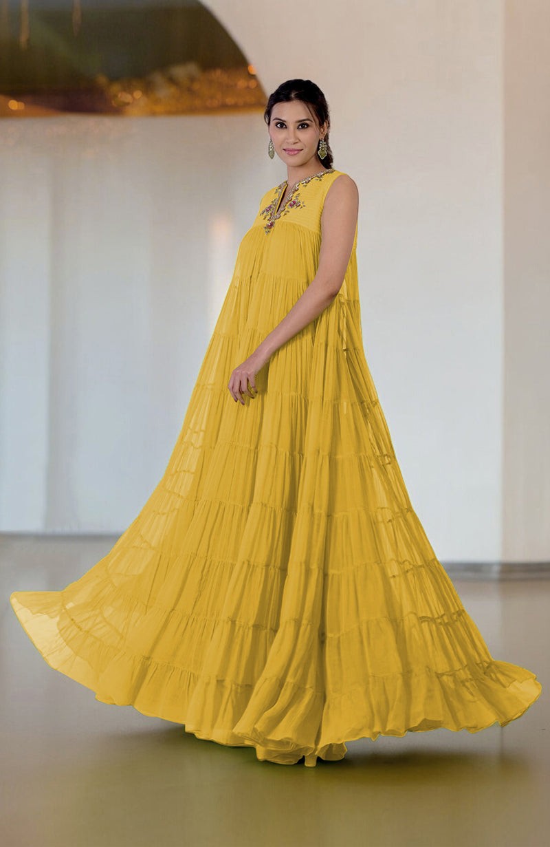 Woman in a yellow tiered dress with embroidered neckline.