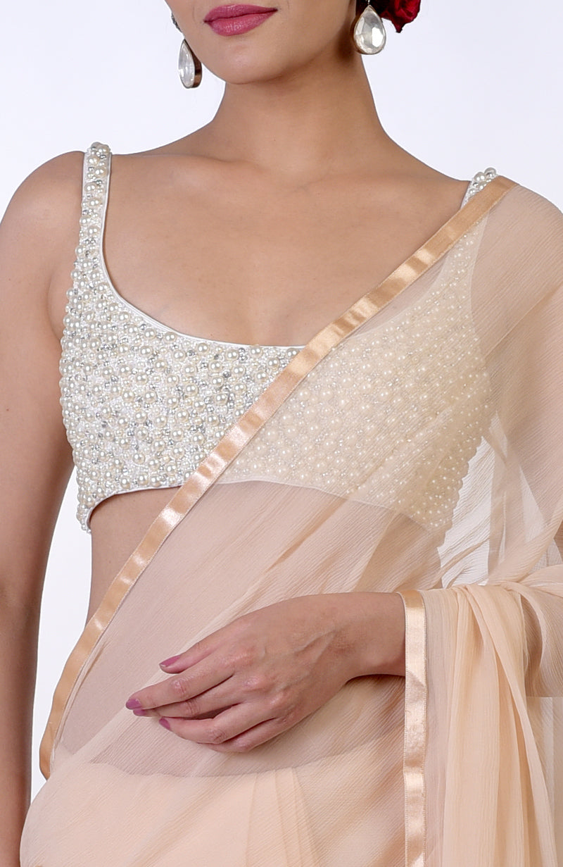 Pearl white hand-beaded blouse with a plain champagne gold chiffon saree.
