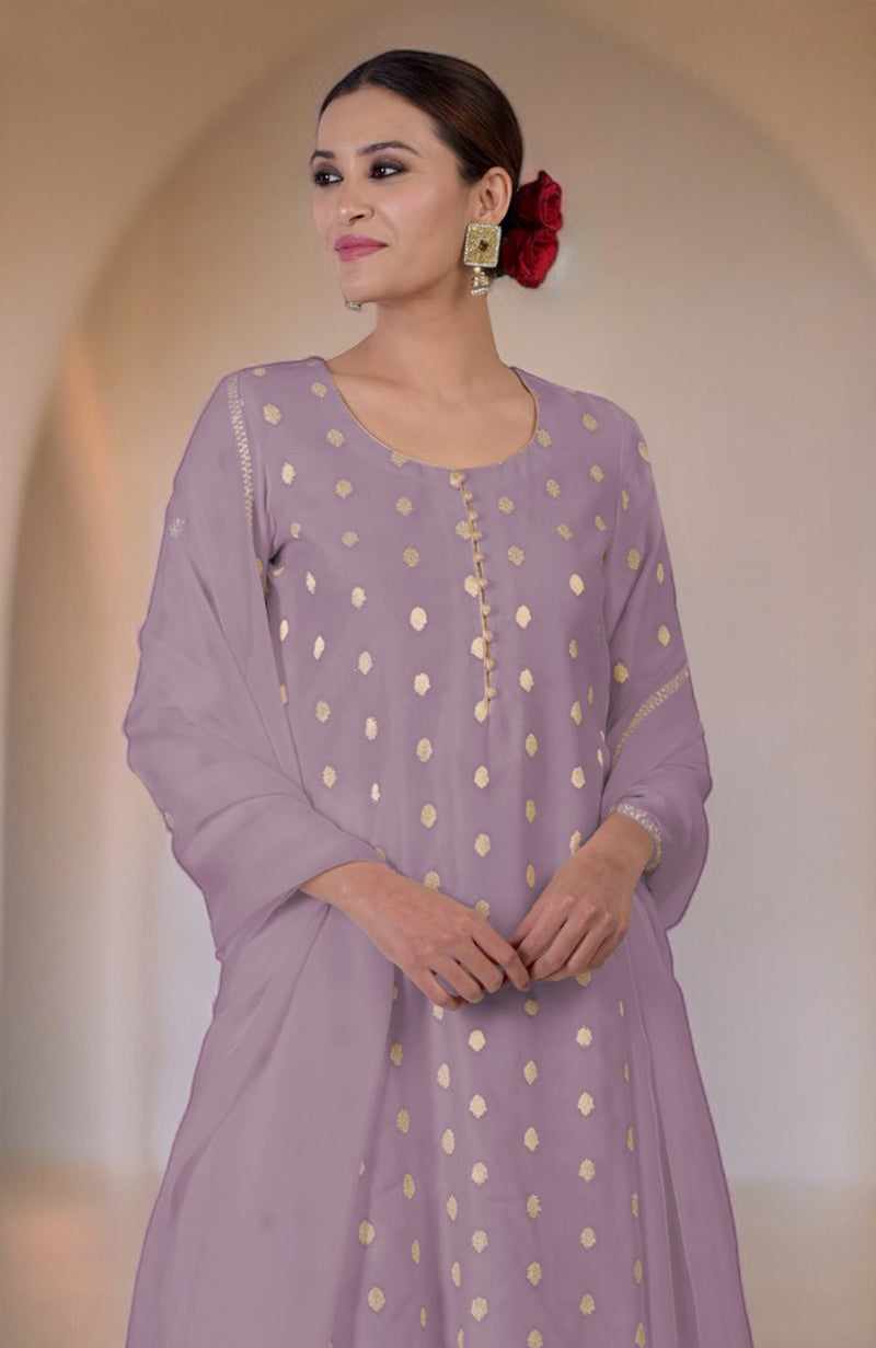 A woman in an elderberry Banarasi bootah and Aari Tilla embroidered sharara set.