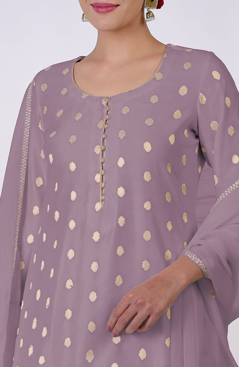 A woman models an elderberry Banarasi bootah and Aari Tilla embroidered sharara set.