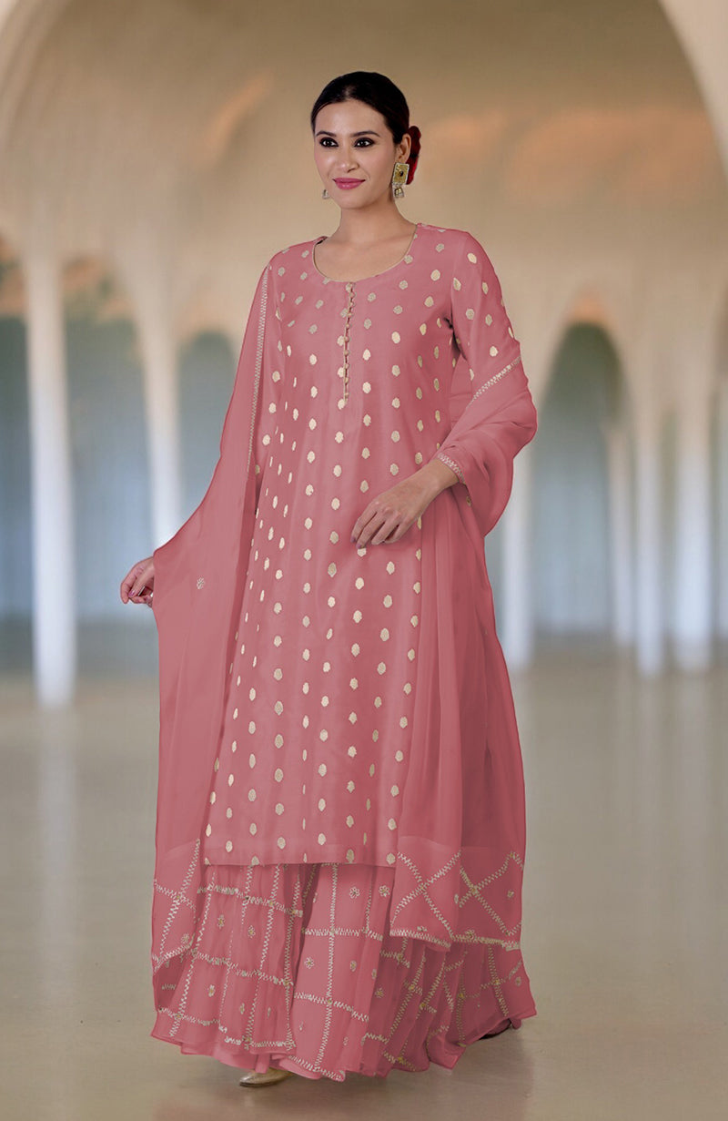 Woman in a pink Banarasi bootah and Aari Tilla embroidered sharara set.
